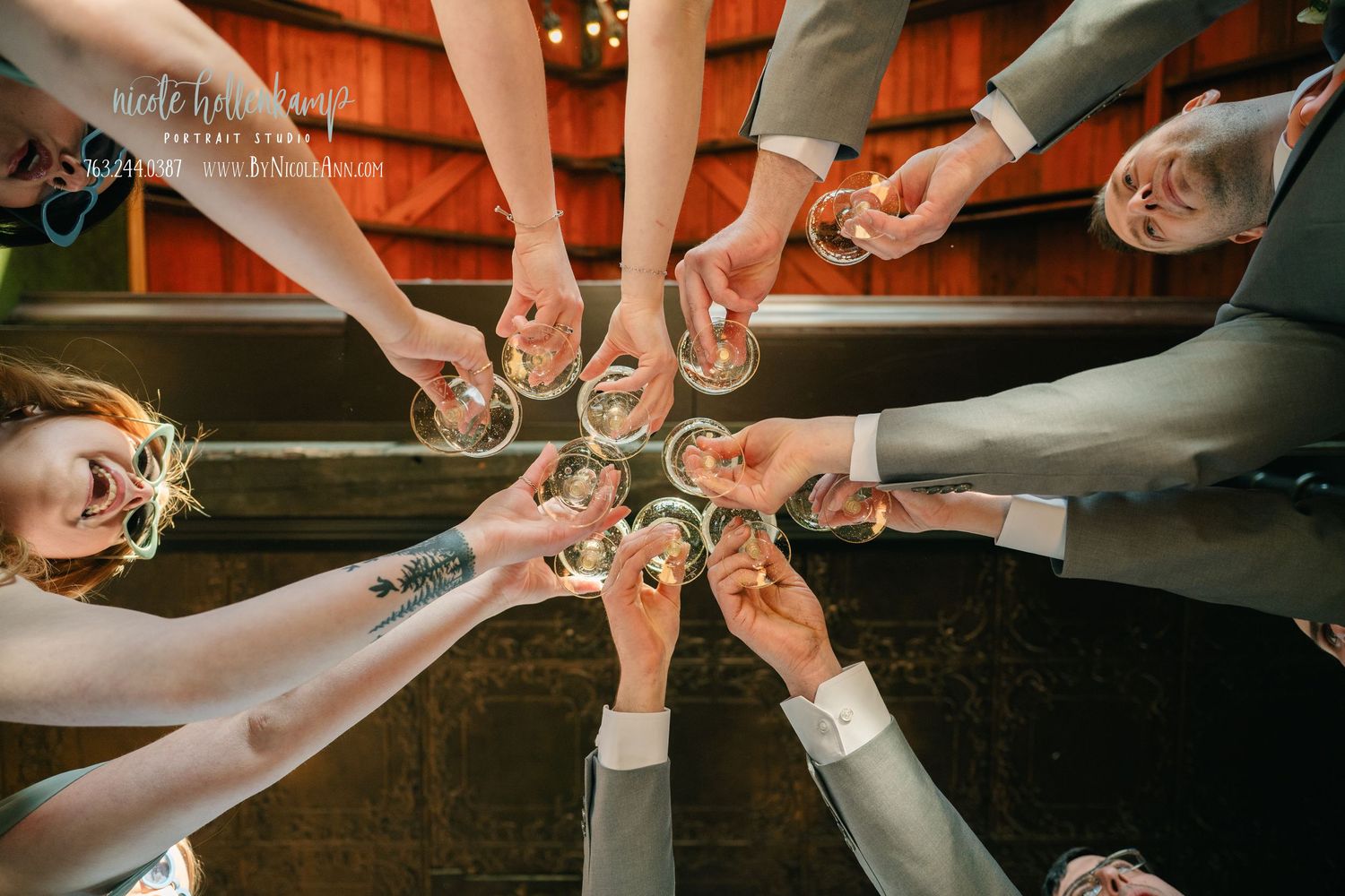People joining hands in a circle to show unity and teamwork in a rustic wooden setting.
