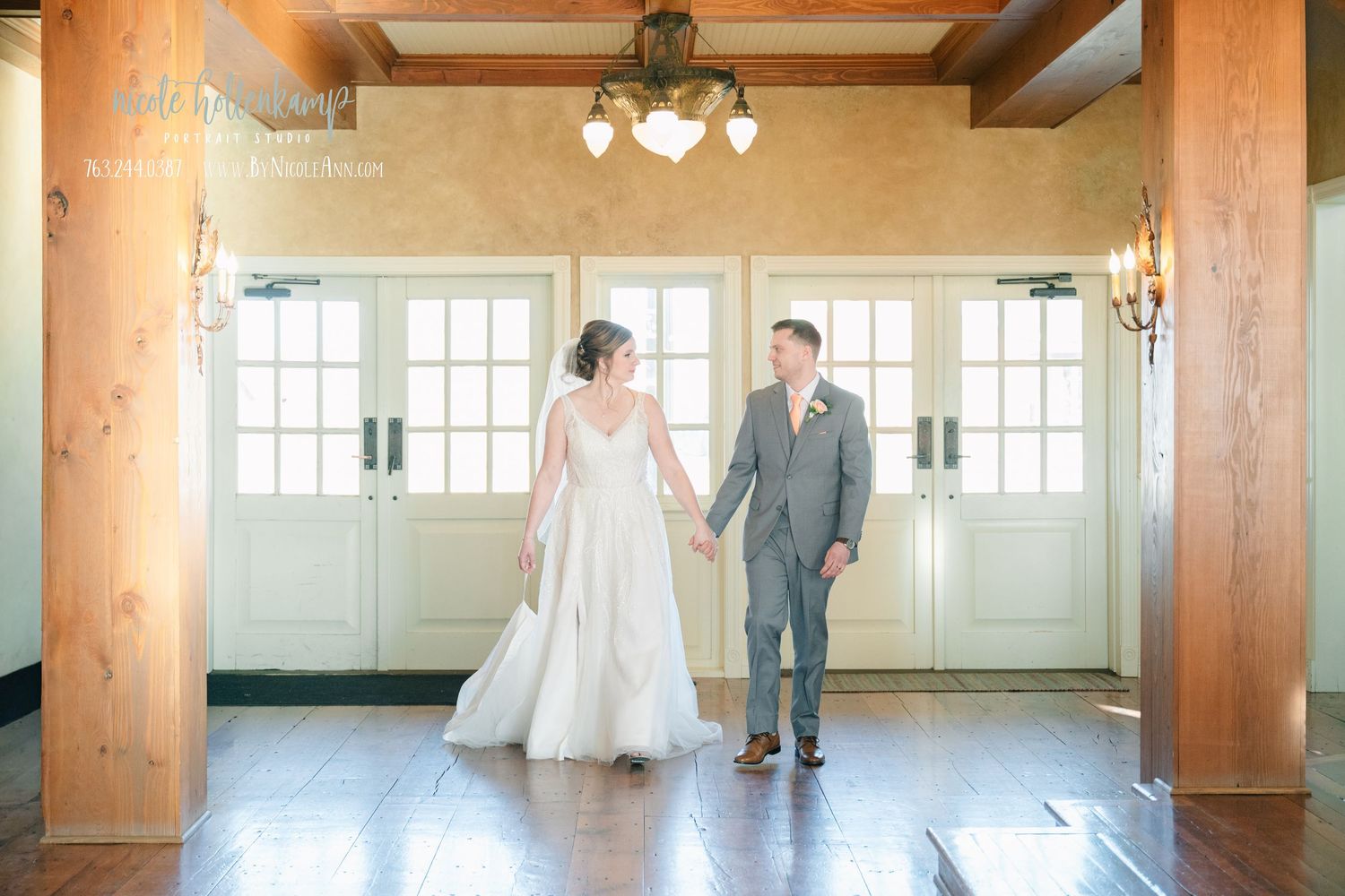 Bride and groom hold hands in elegant venue with wood floors and white French doors on their wedding day. Crooked Willow Osakis