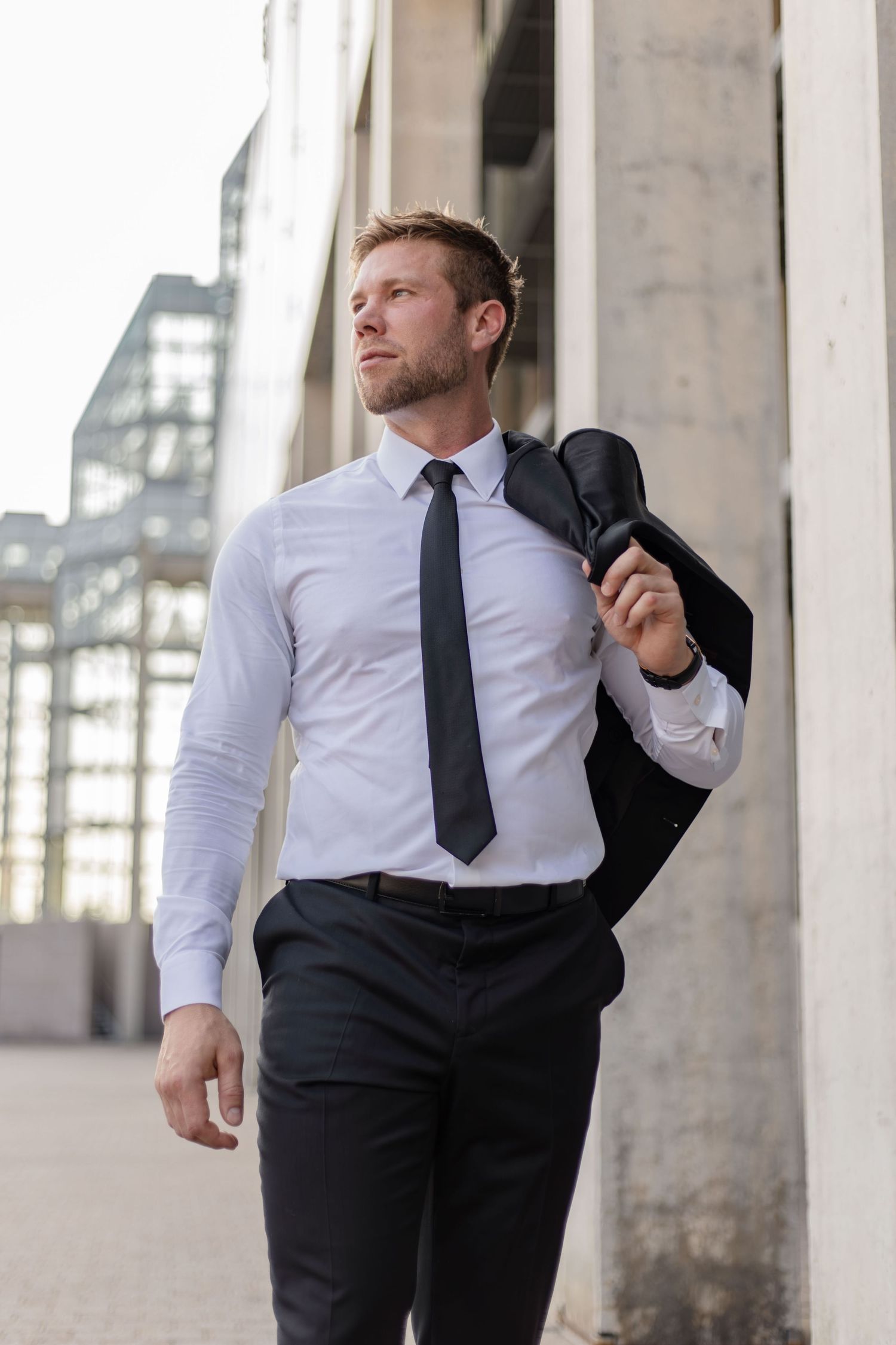 Person in business attire striking various casual poses against urban backdrop.