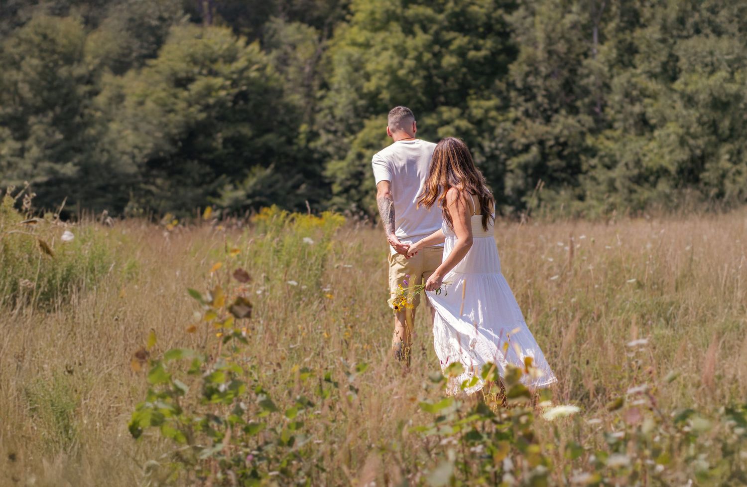 Scenic field with tall grass and trees creating a natural romantic backdrop.