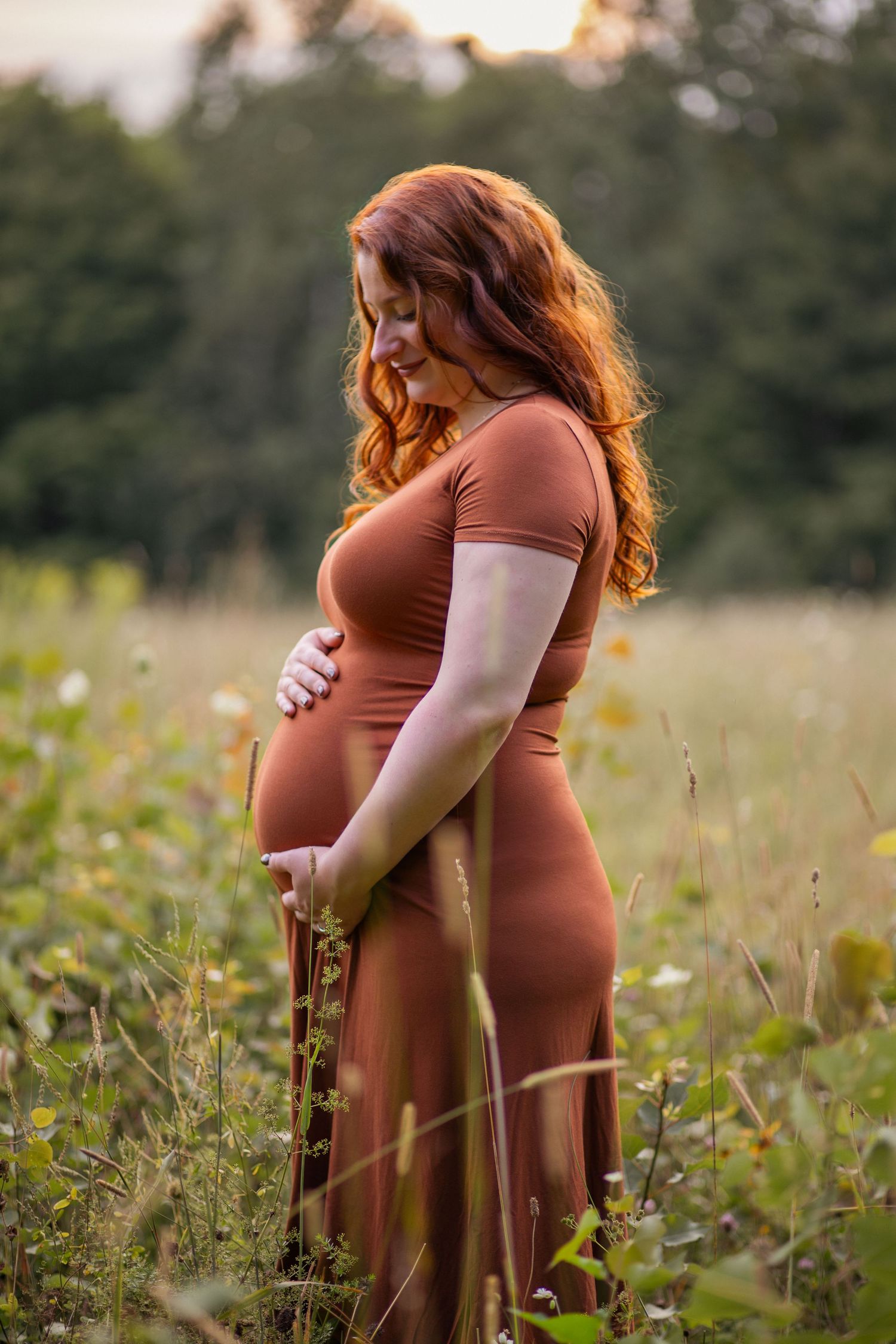 Maternity photography session captures intimate moments between a couple in a rustic meadow setting.