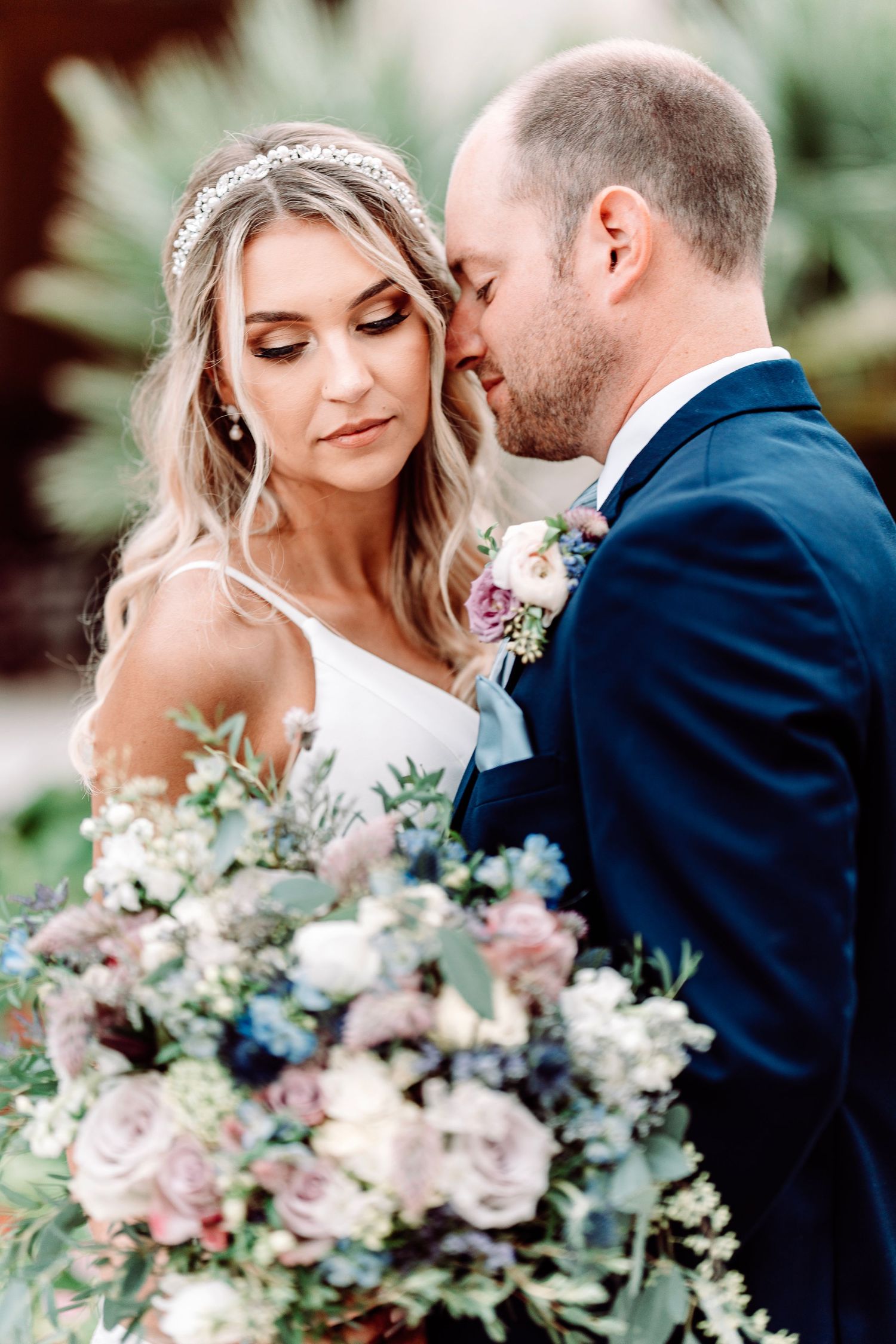 Intimate portrait with lush floral bouquet against garden background.