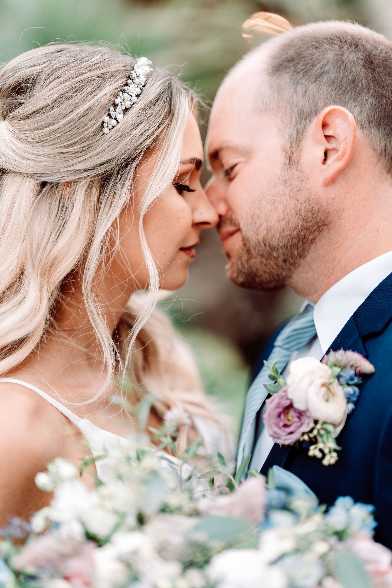Romantic close-up of couple with delicate florals and bridal accessories.
