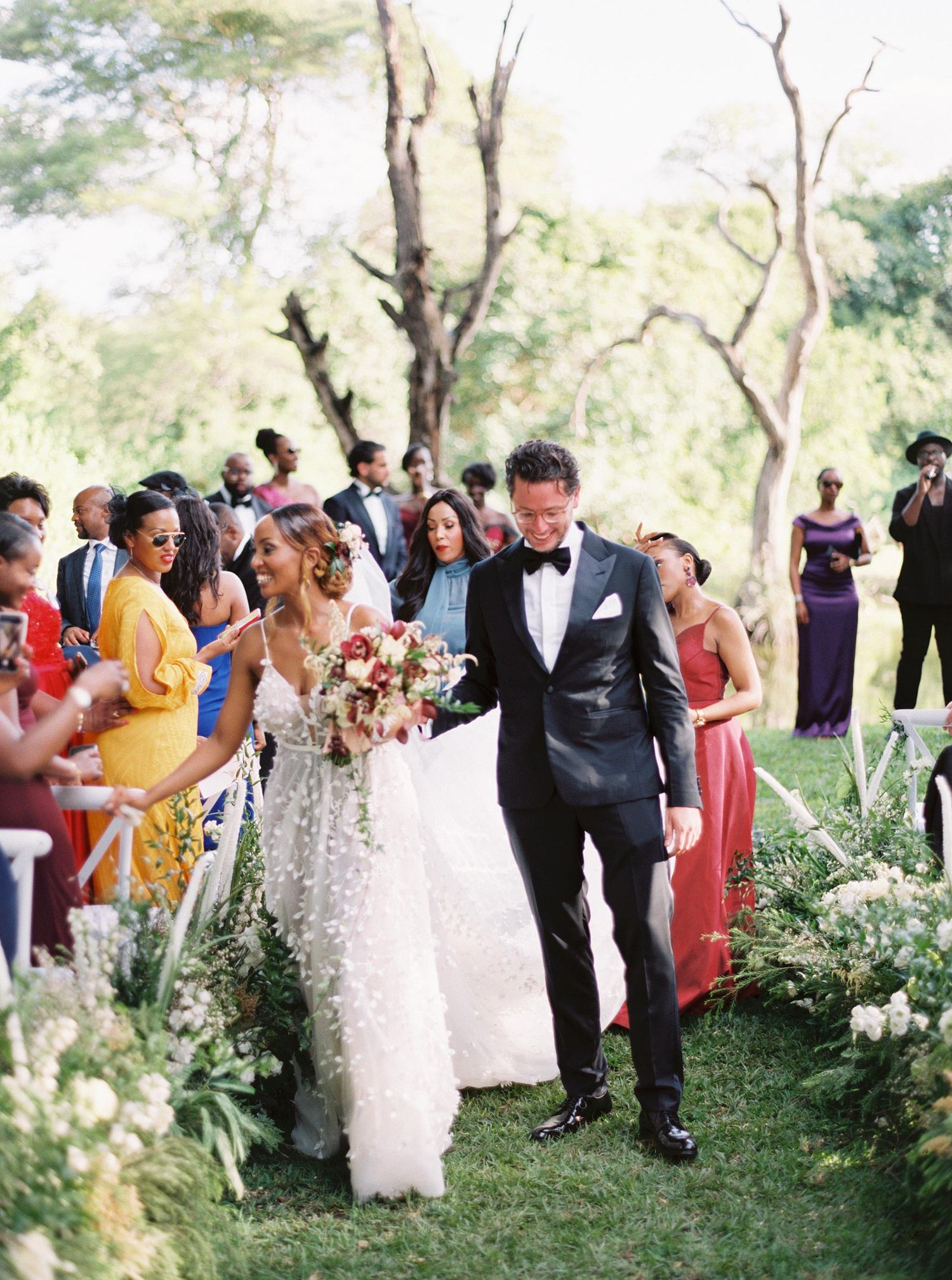 Joyful wedding recessional at The Royal Livingstone, Zambia, Africa, with a happy couple and vibrant guests celebrating.
