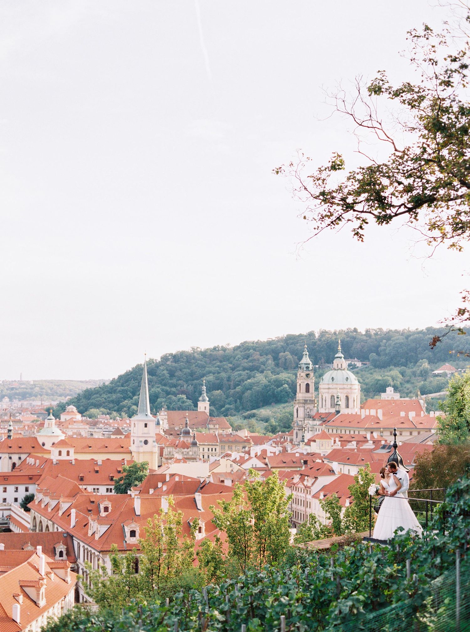 Bride and groom smiling, standing close together, with Prague's scenic backdrop. Captured by the top wedding photographe
