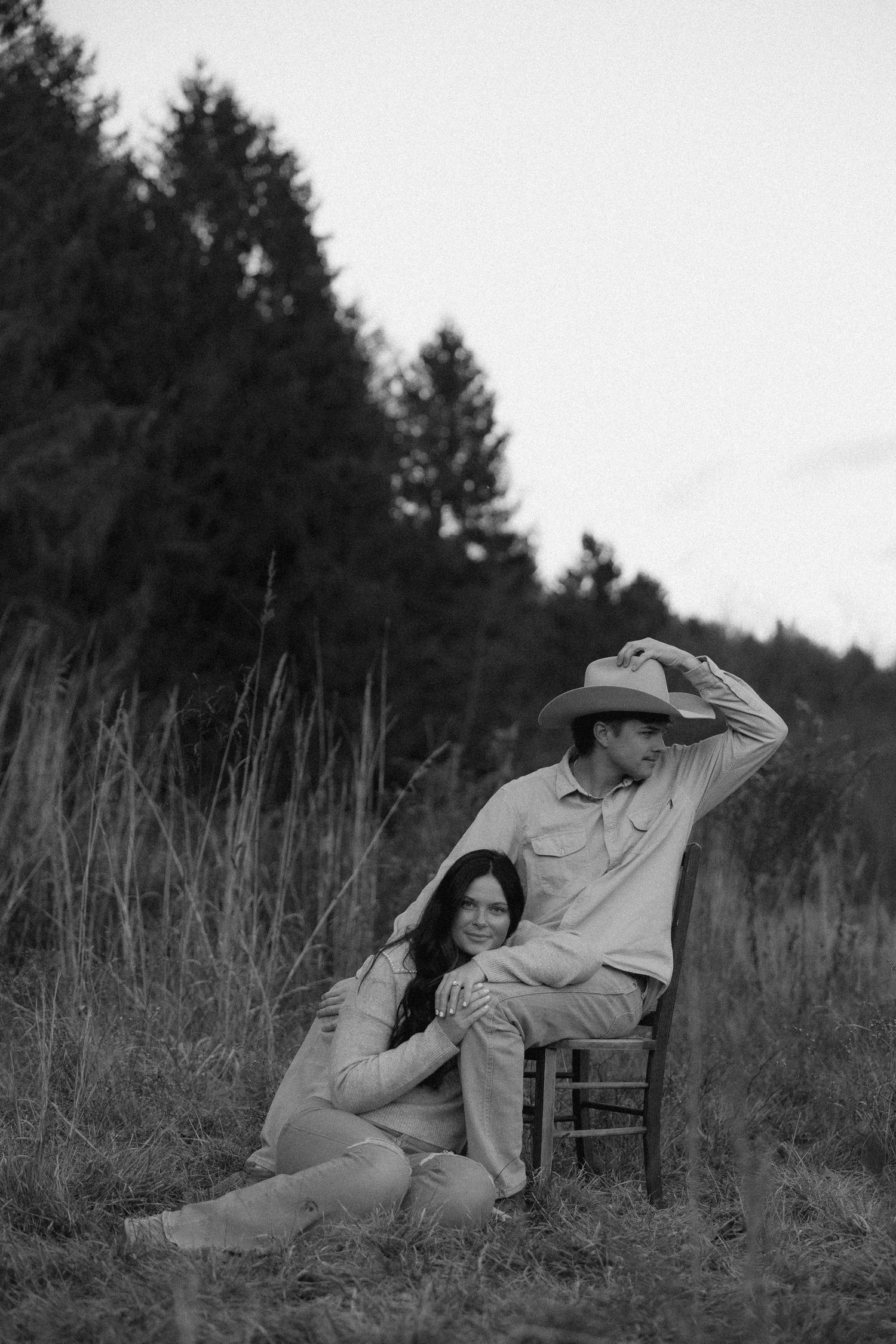 A black and white photo series shows two people lounging in chairs among tall grass in a pastoral setting.