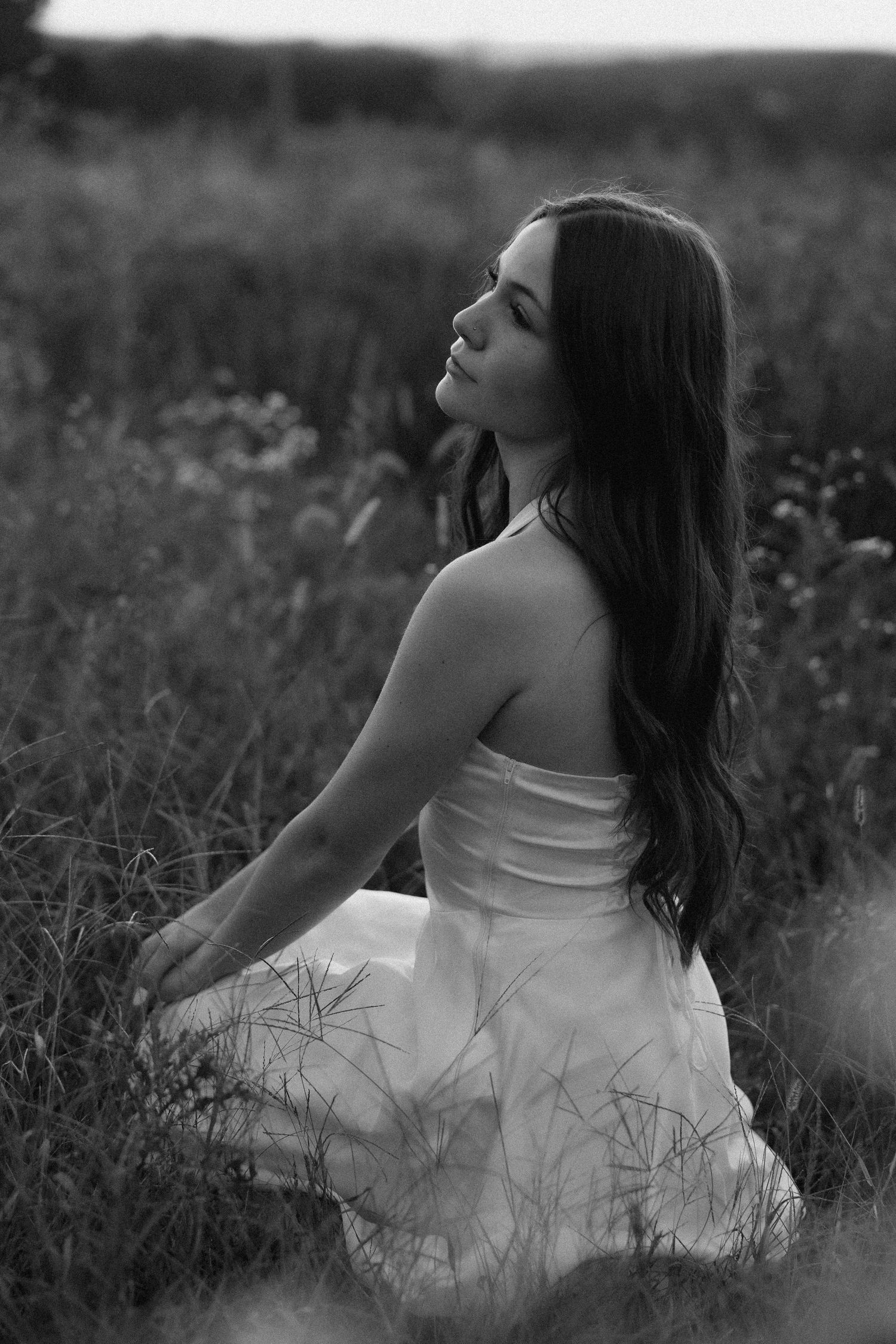 Black and white artistic portrait series showing graceful poses among wildflowers and tall grass.