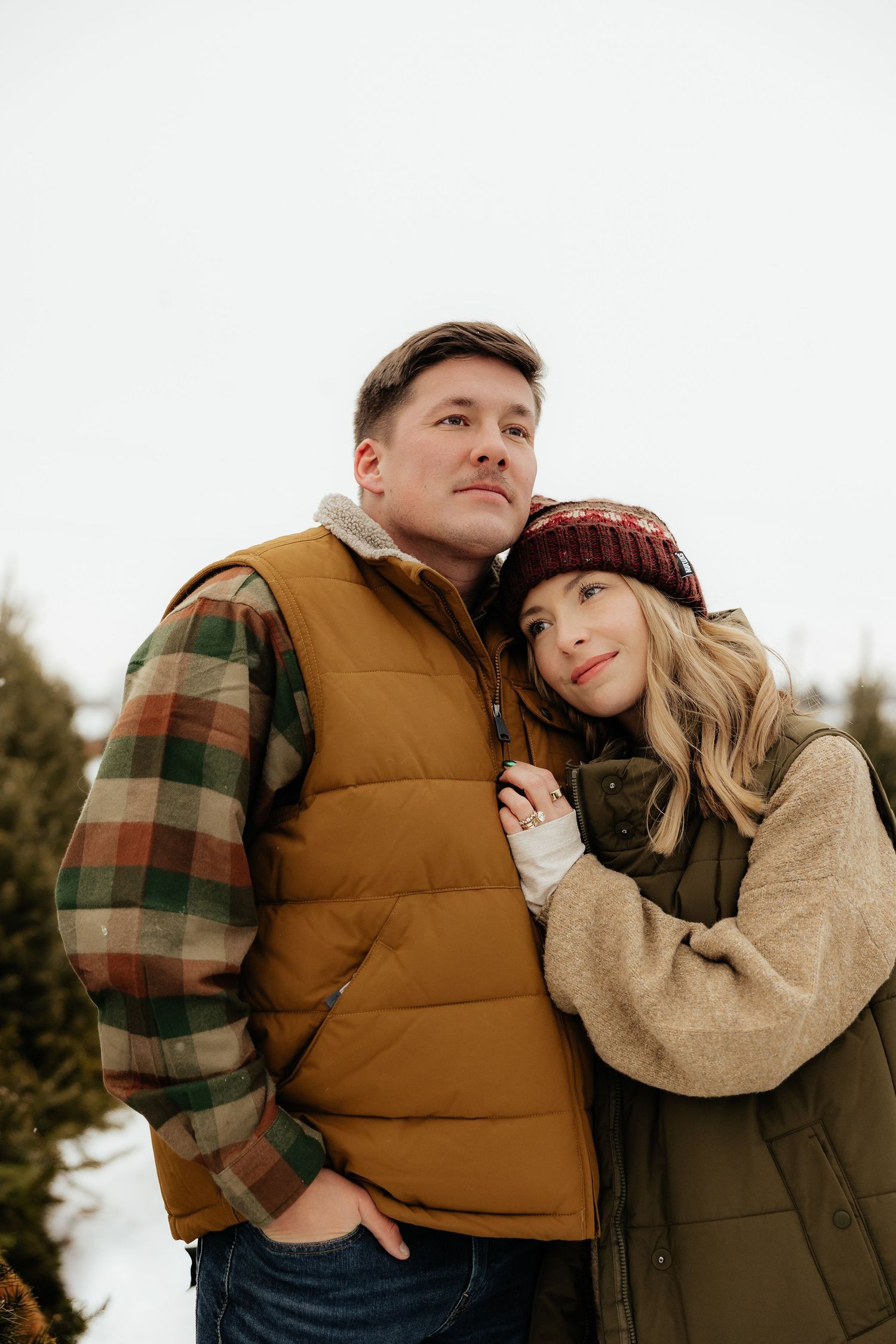 A couple in cozy winter attire embraces outdoors against a bright background in a series of romantic poses.