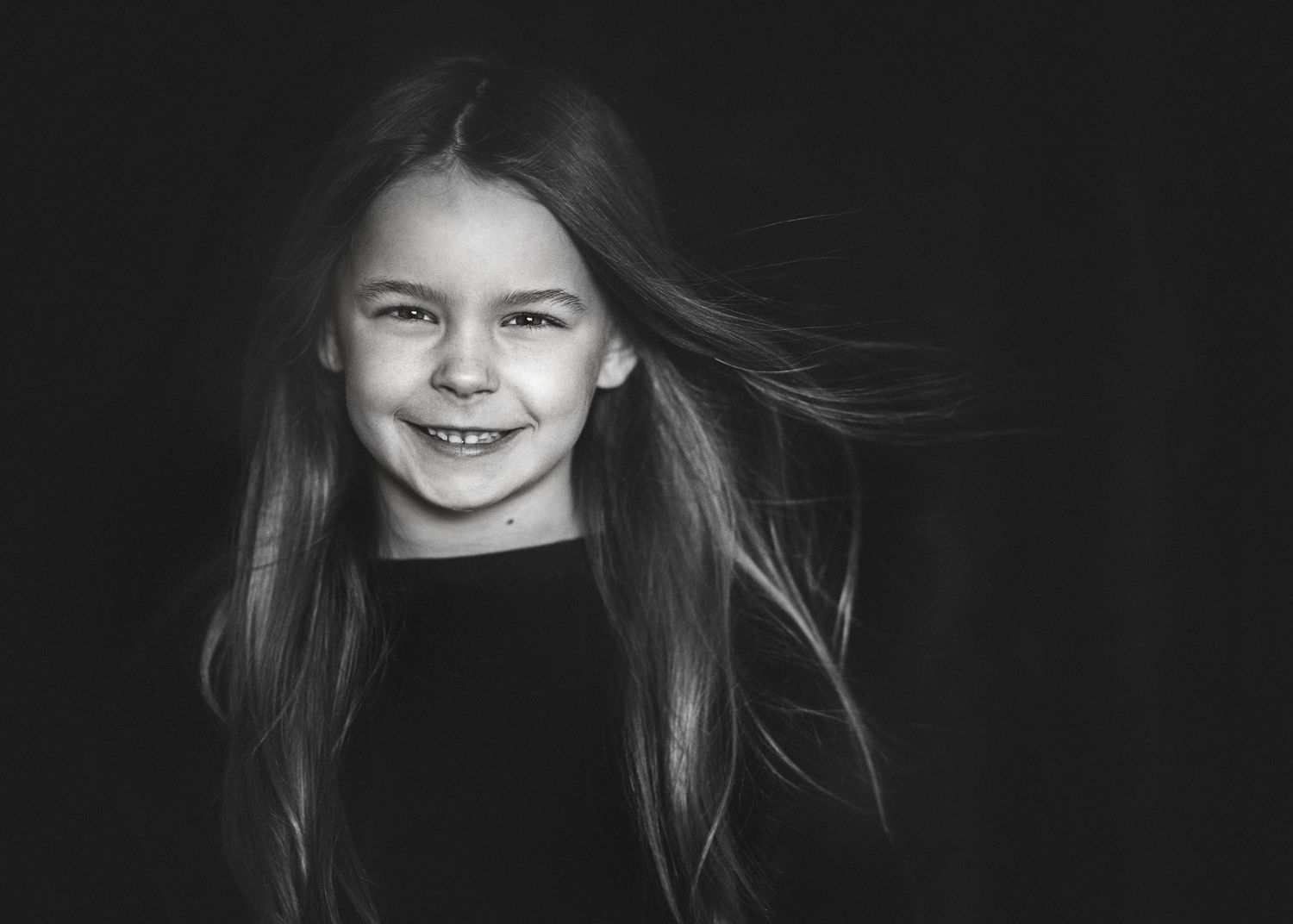 Black and white image of a young girl with her hair blowing