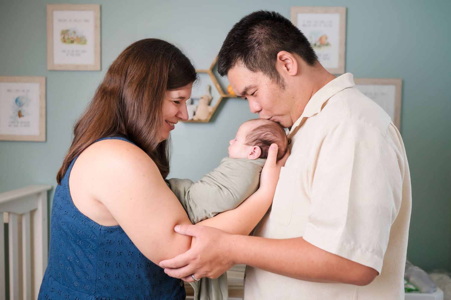 Medical professional checks pregnant woman's belly with ultrasound device in hospital examination room.