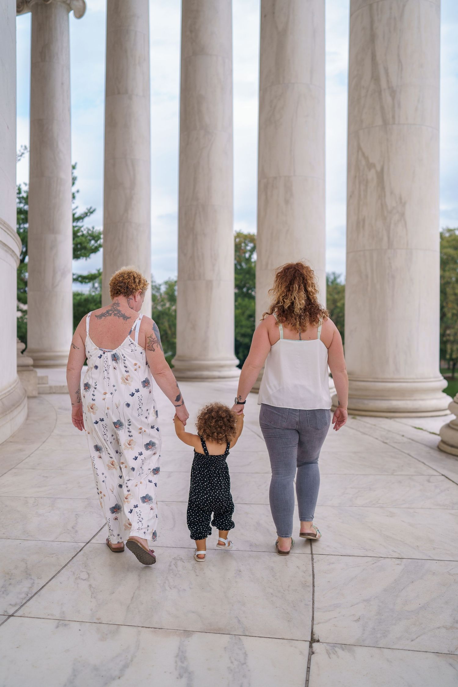 Family of three walking hand-in-hand at the Jefferson Memorial in Washington DC