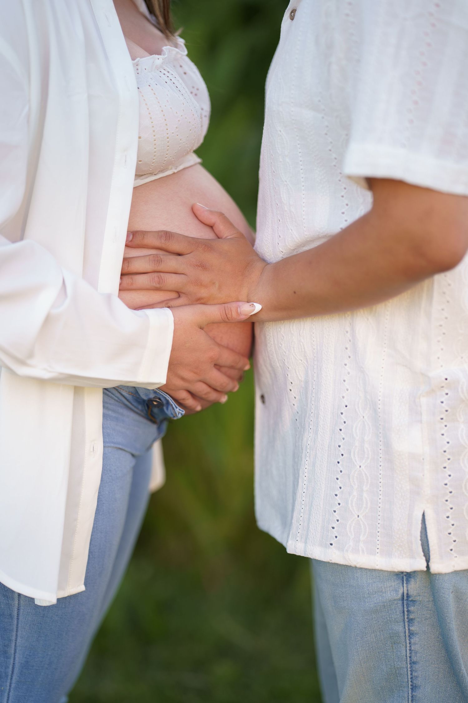 Expecting couple sharing a quiet moment in a field at sunset in Frederick, MD.