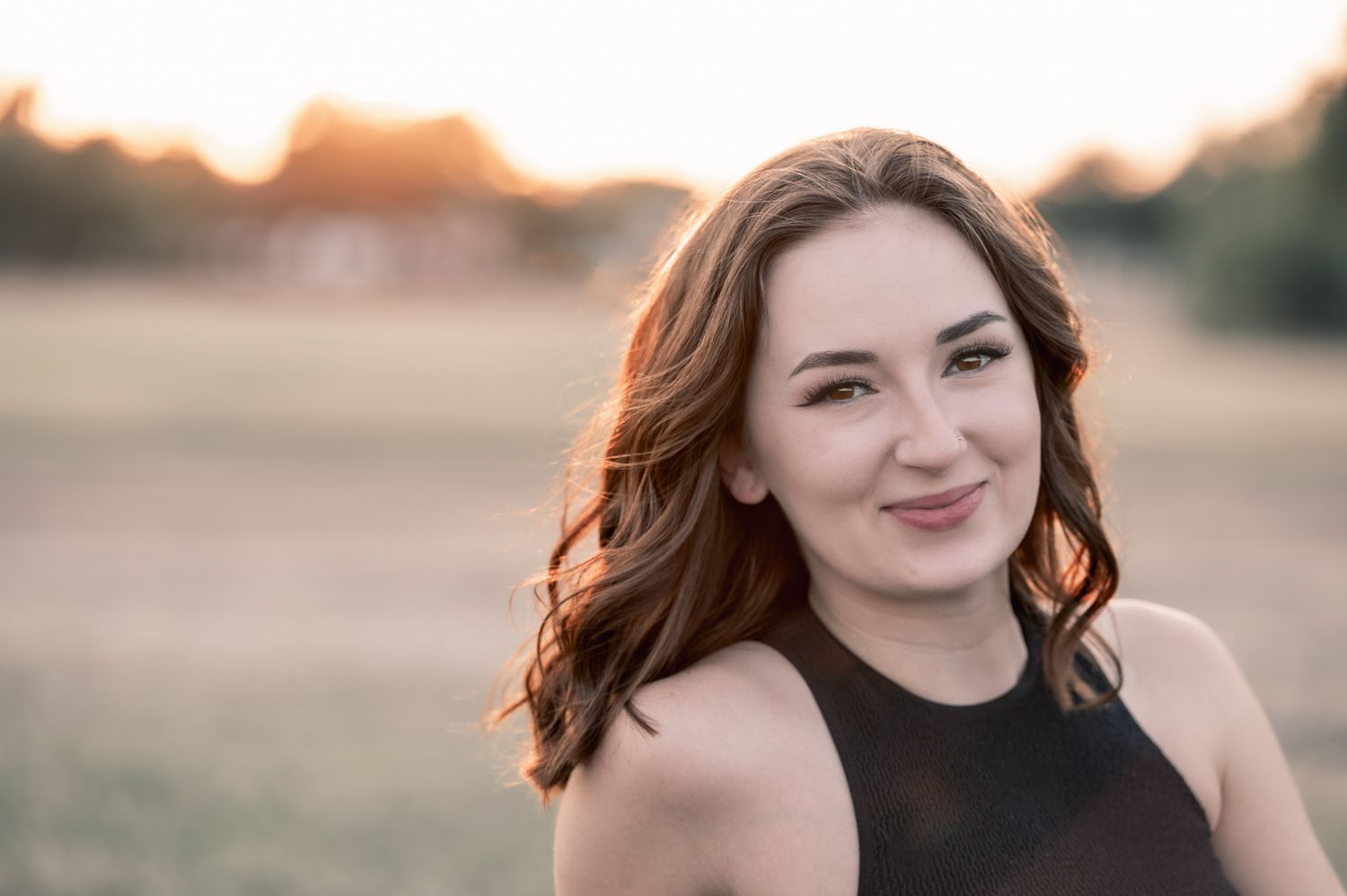 Portrait against blurred sunset with natural hair movement.