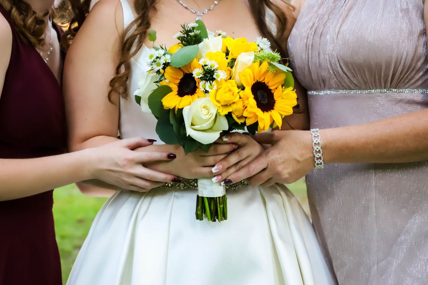 Wedding portrait of a bride holding a sunflower and white rose bouquet with bridesmaids in High Springs, Florida.