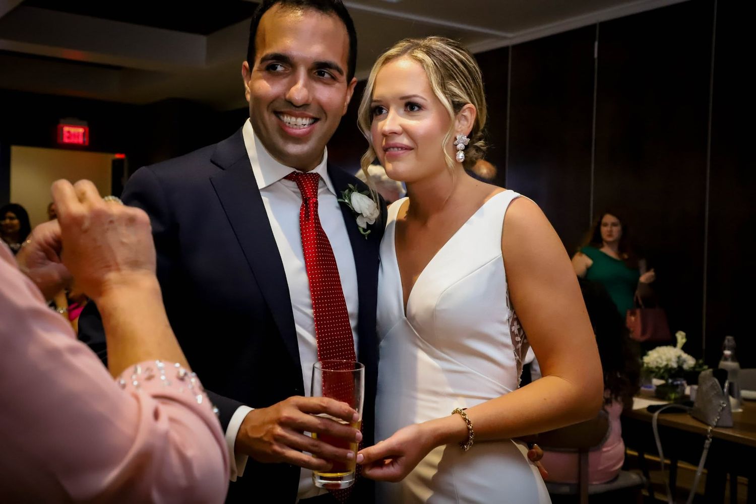 Smiling bride and groom pose together at their wedding reception, with the groom holding a drink at Spurrier’s in Gainesville, Florida.