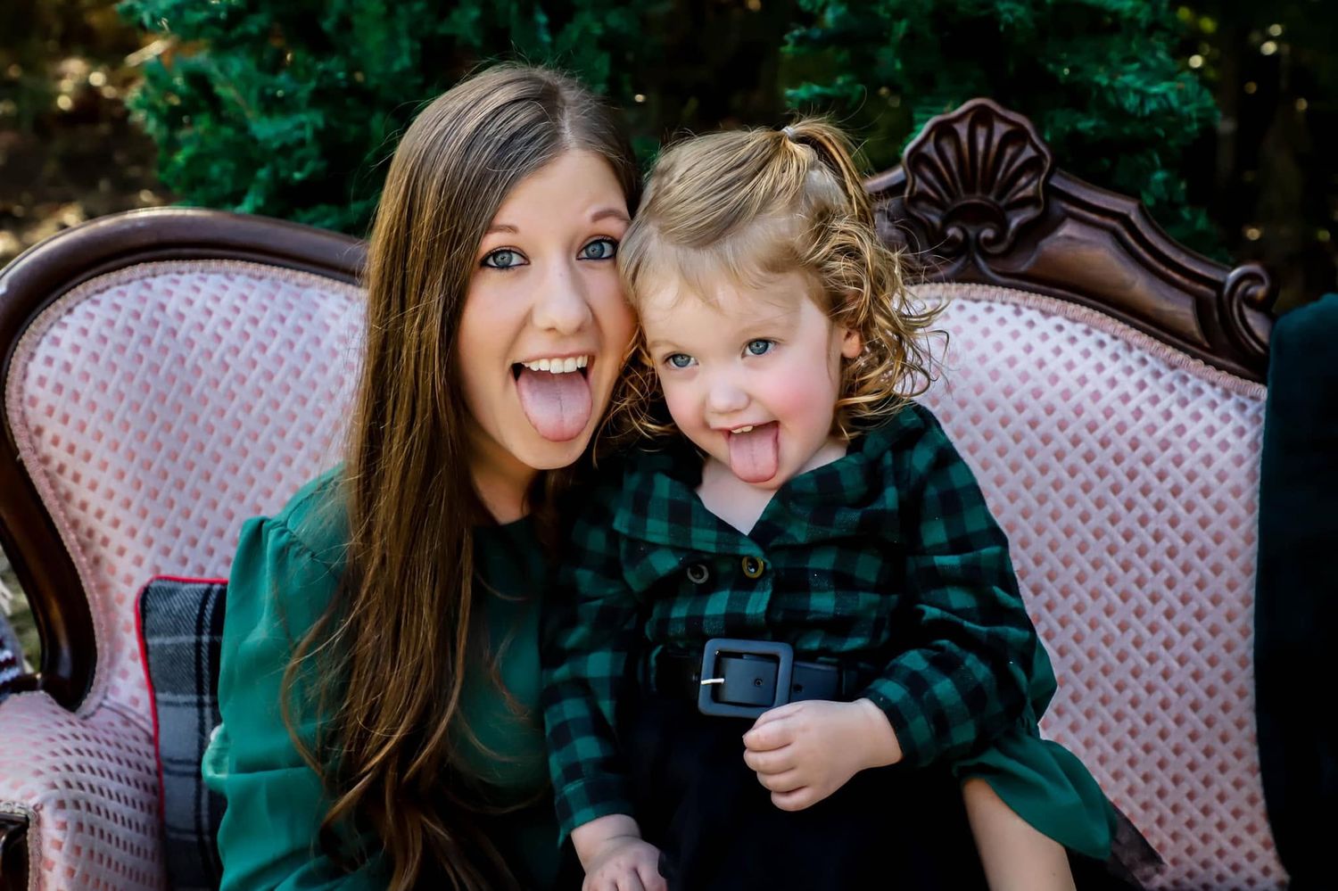 Holiday mini session of a woman and toddler in matching green plaid outfits sitting on a vintage chair in Lake City, Florida.