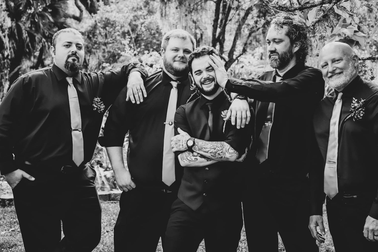 Black and white wedding photo of five groomsmen laughing together outdoors in Gainesville, Florida