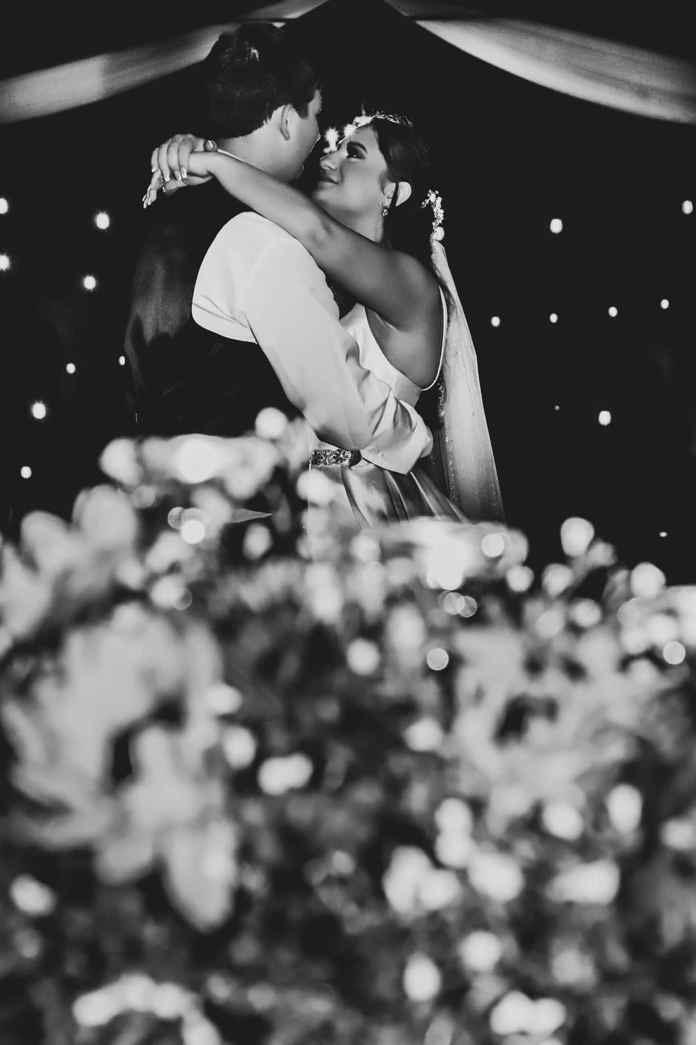 Black and white photo of a bride and groom sharing their first dance under lights in Ocala, Florida.