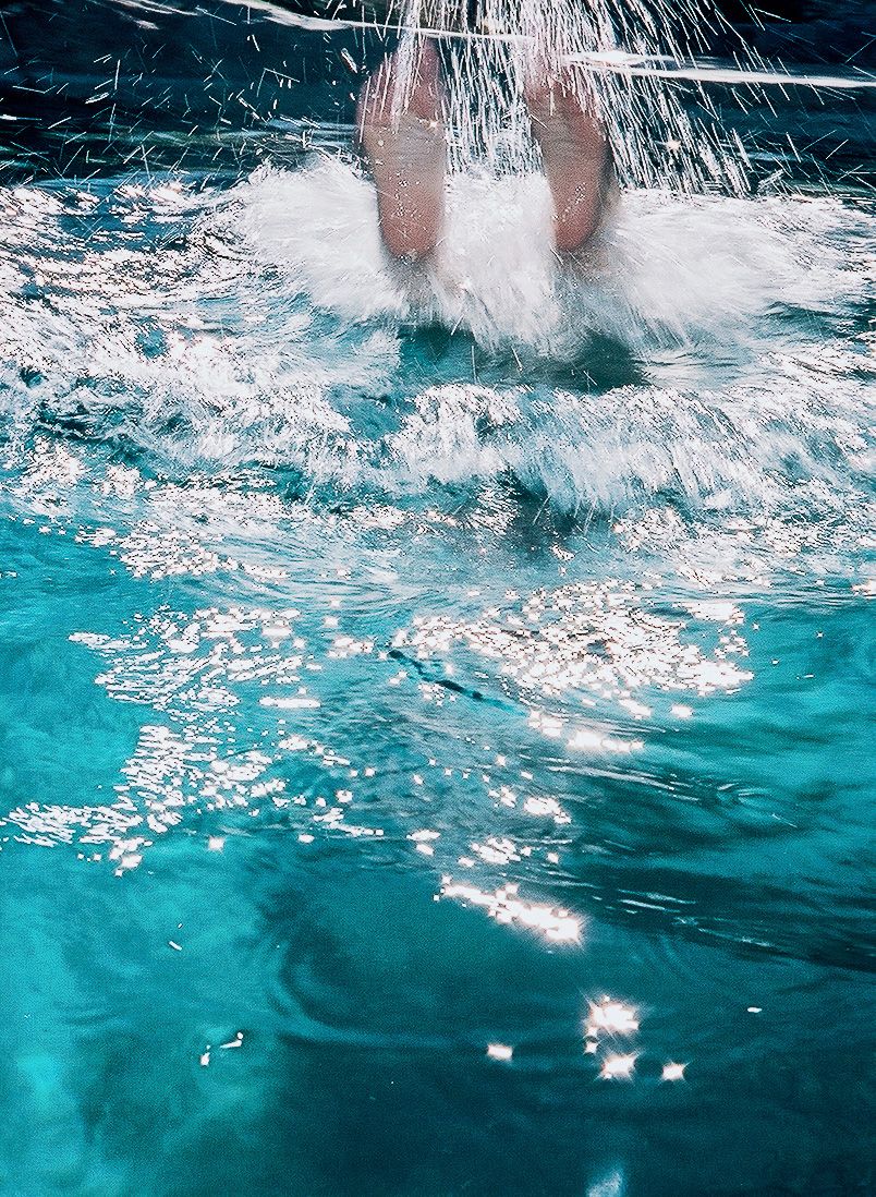 feet splashing in swimming pool