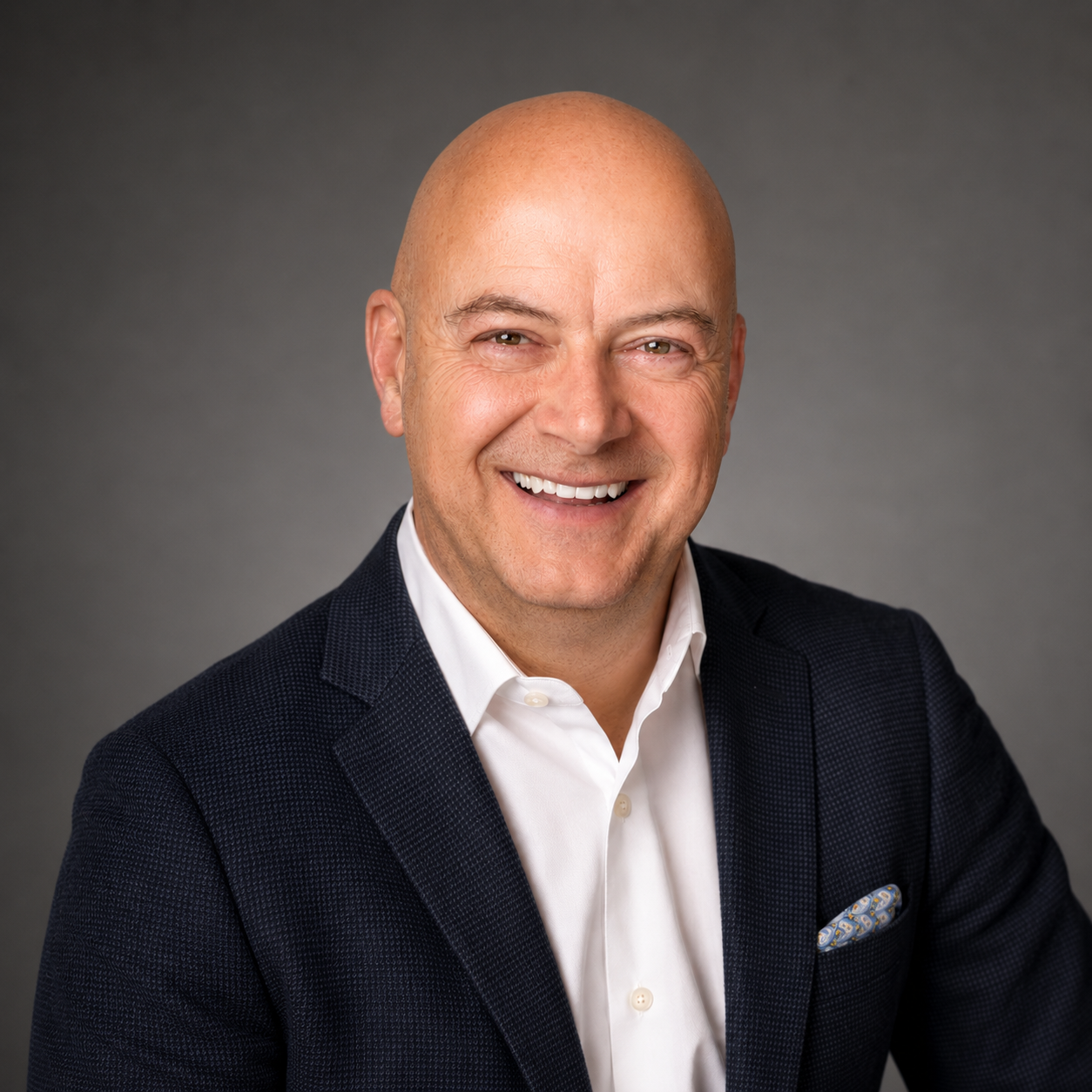 Scott Kurfman, founder of Alchemy, smiling in a dark blazer.