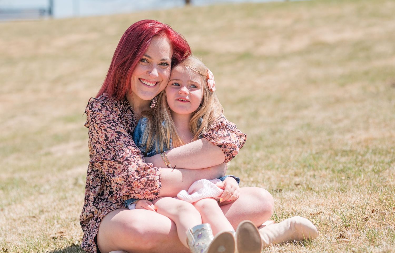 Mommy and me photo of mother hugging young daughter outdoors, candid Colorado family photography in natural light, Denver family photographe