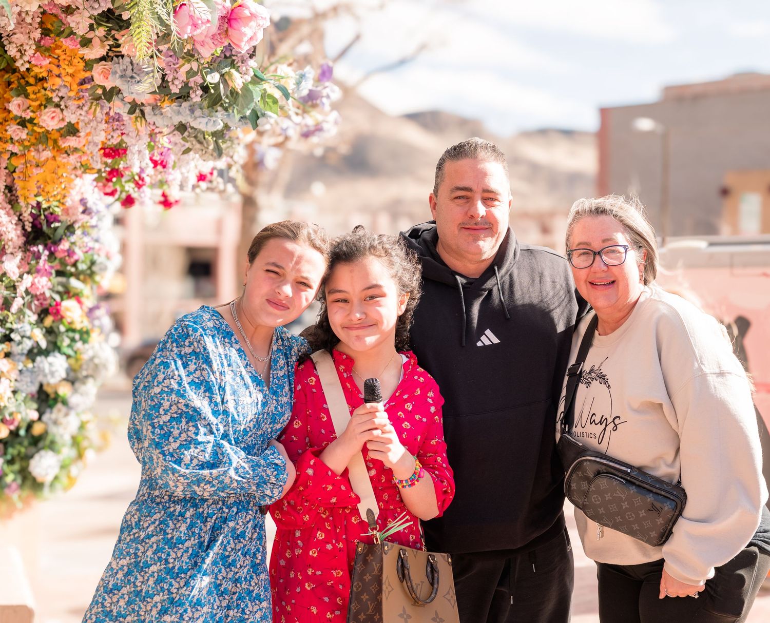 Family portrait at outdoor event with floral arch, candid Colorado event photography, natural light Denver photographer