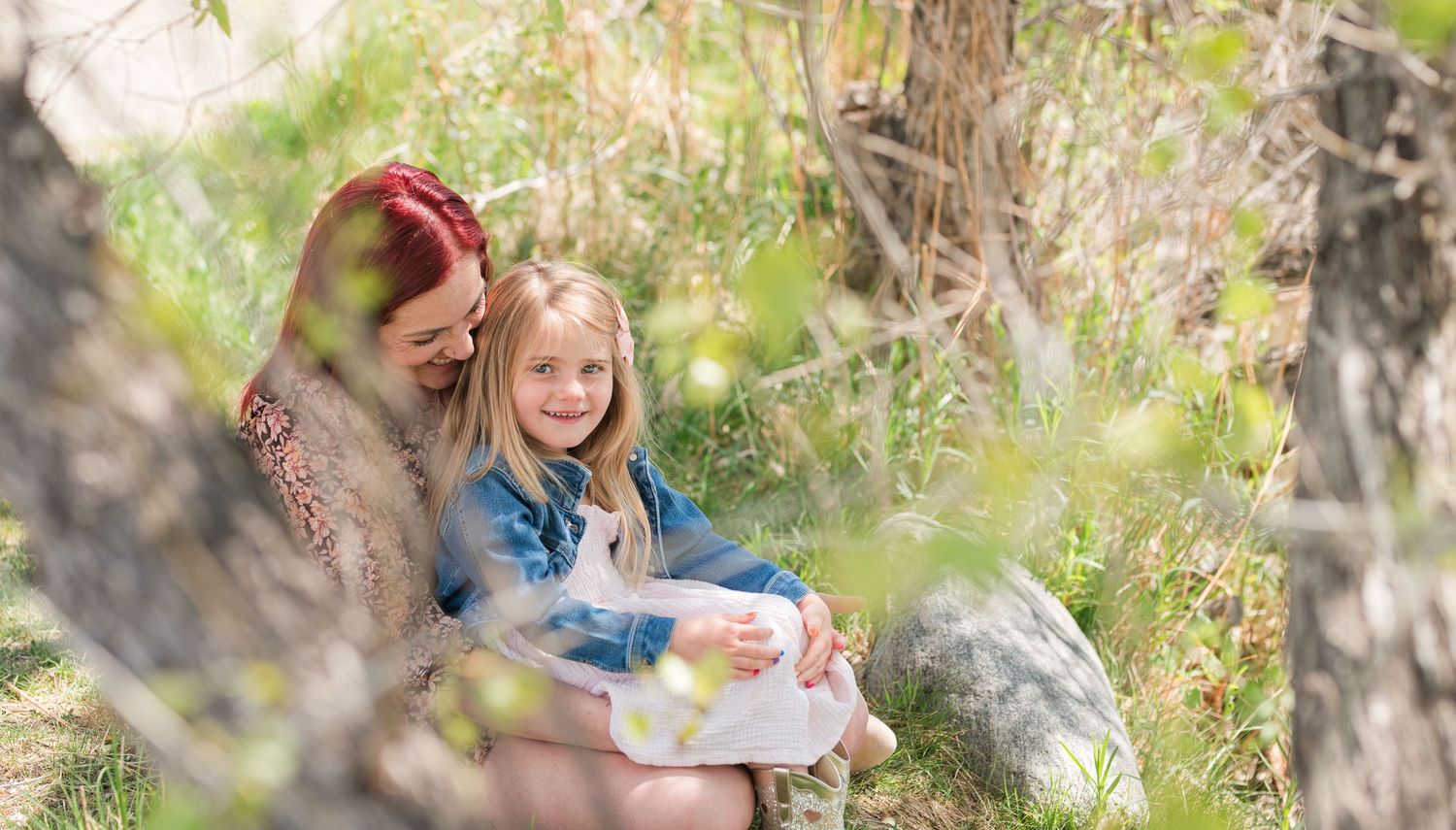 Mommy and me photo of mother and daughter sitting in nature, candid Colorado family photography with soft light, Denver family photographer