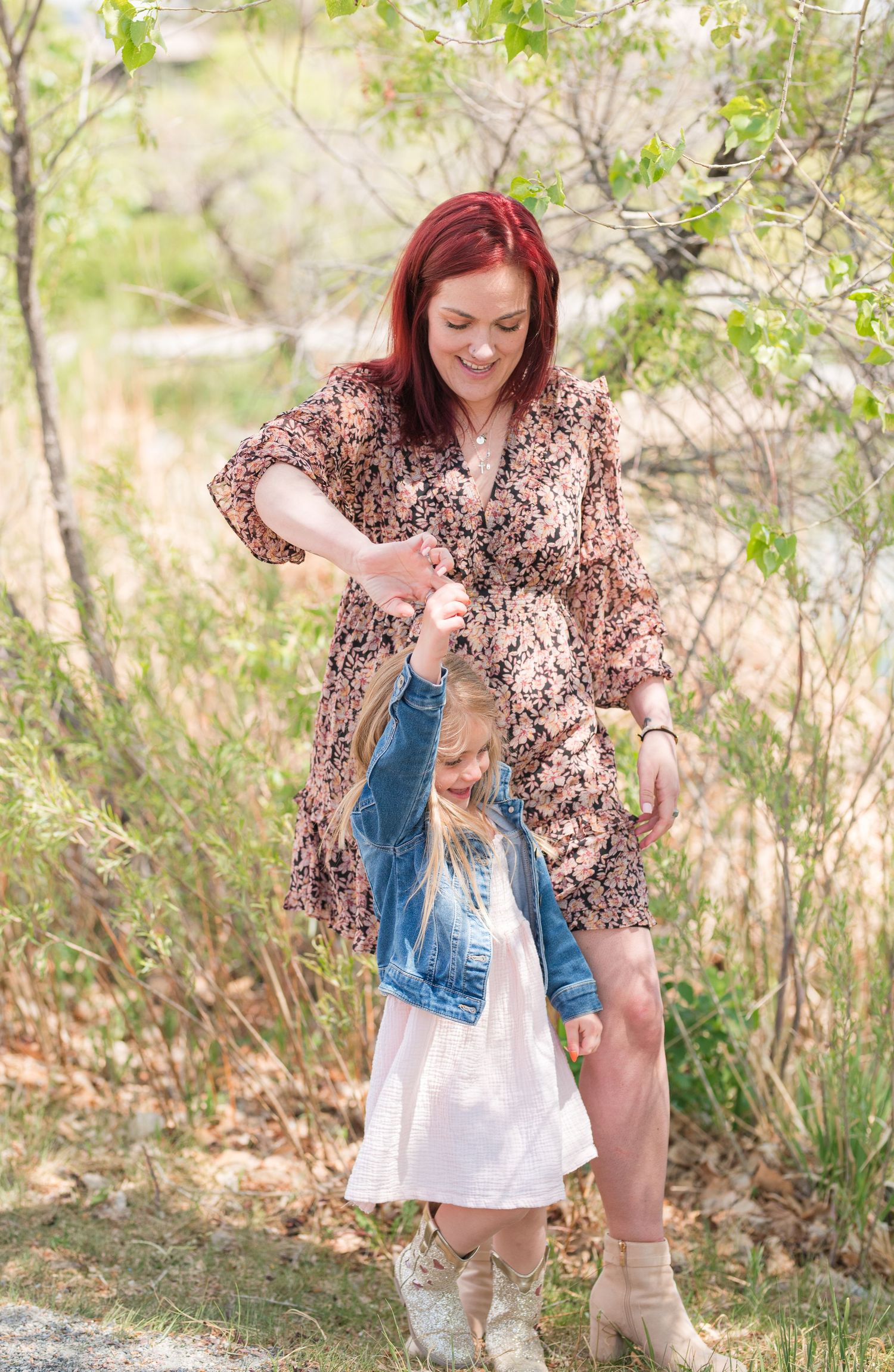 Mommy and me photo of mother twirling daughter outdoors, candid Colorado family photography, natural light Denver photographer spring time