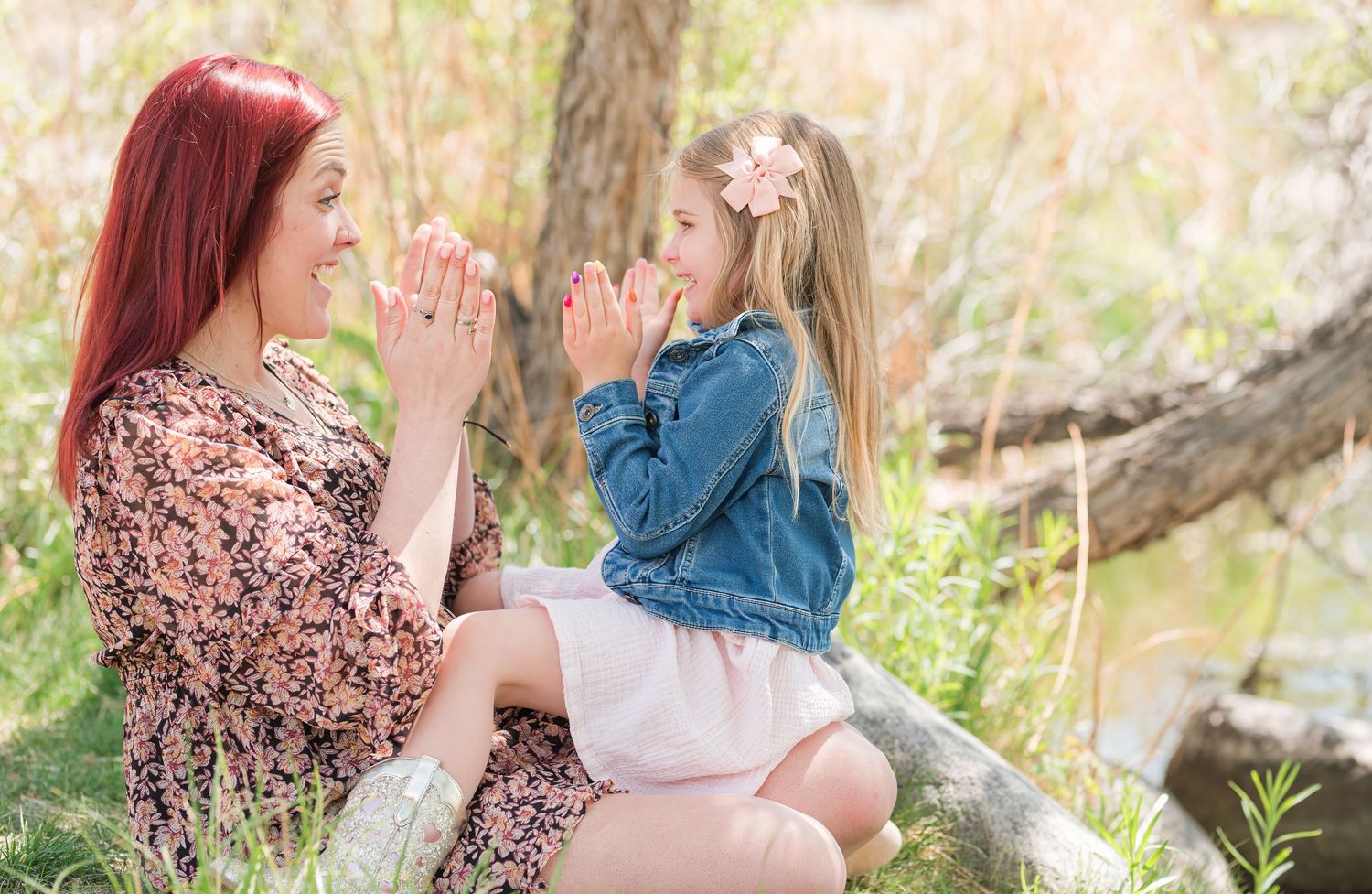 Mommy and me photo of mother and daughter playing clapping game, candid Colorado family photography, natural light Denver photographer happy