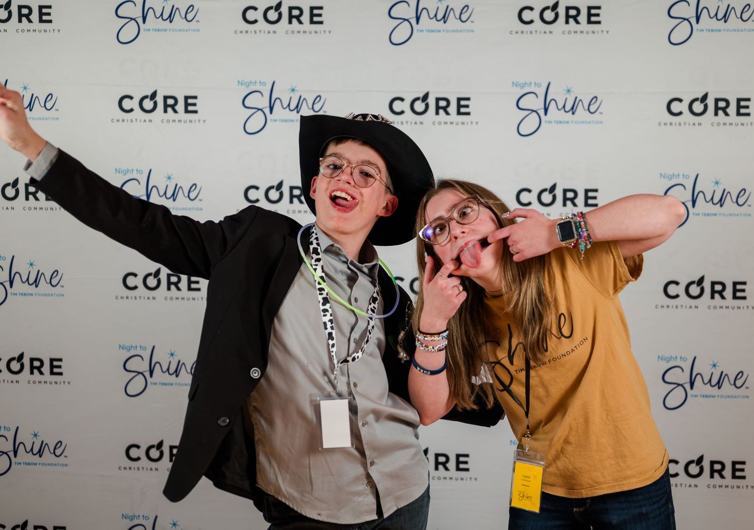 Guests posing playfully at Night to Shine event, fun step-and-repeat portrait capturing joy, personality, and an inclusive celebration atmos