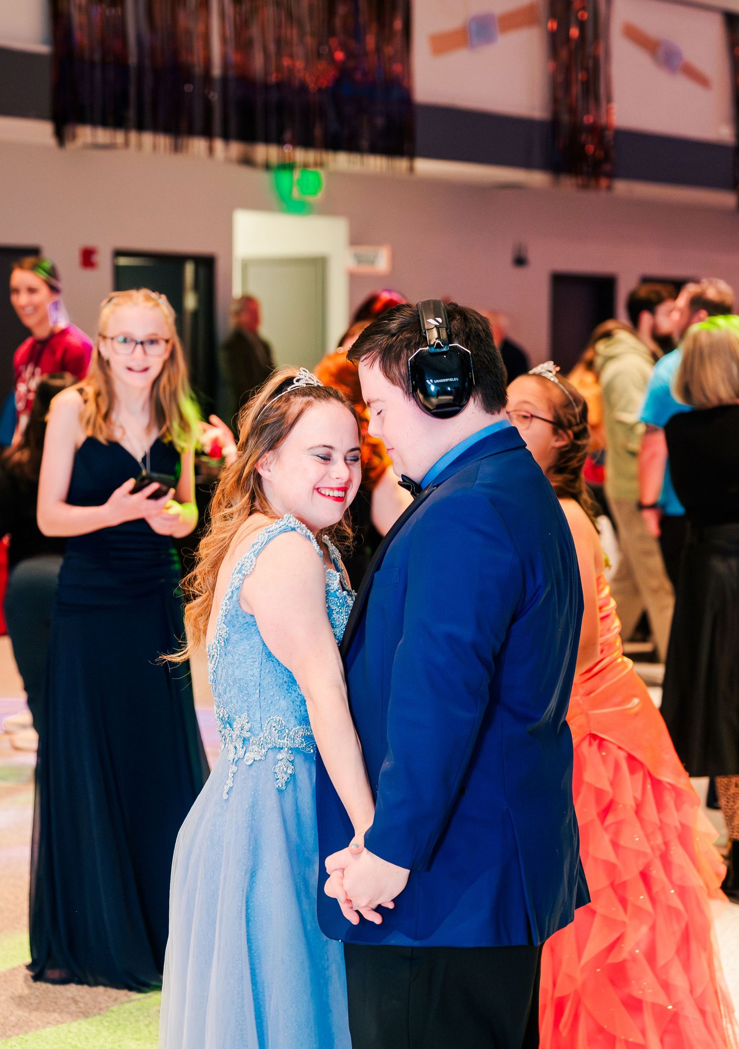 Couple dances closely at Night to Shine, holding hands and smiling, capturing a heartfelt moment of joy, connection, and inclusive celebrati