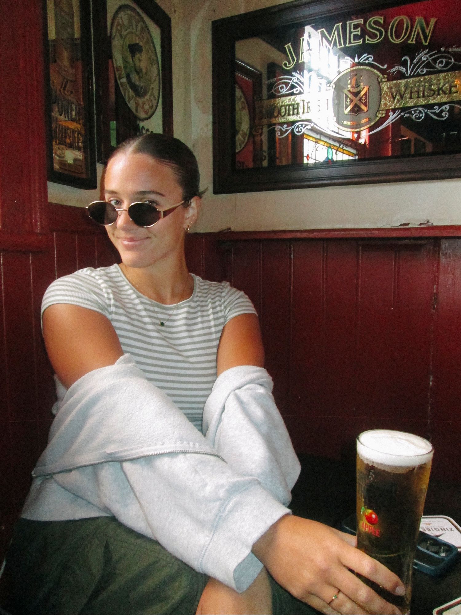 People relaxing in a dimly lit pub with Jameson whiskey signs visible in the background.