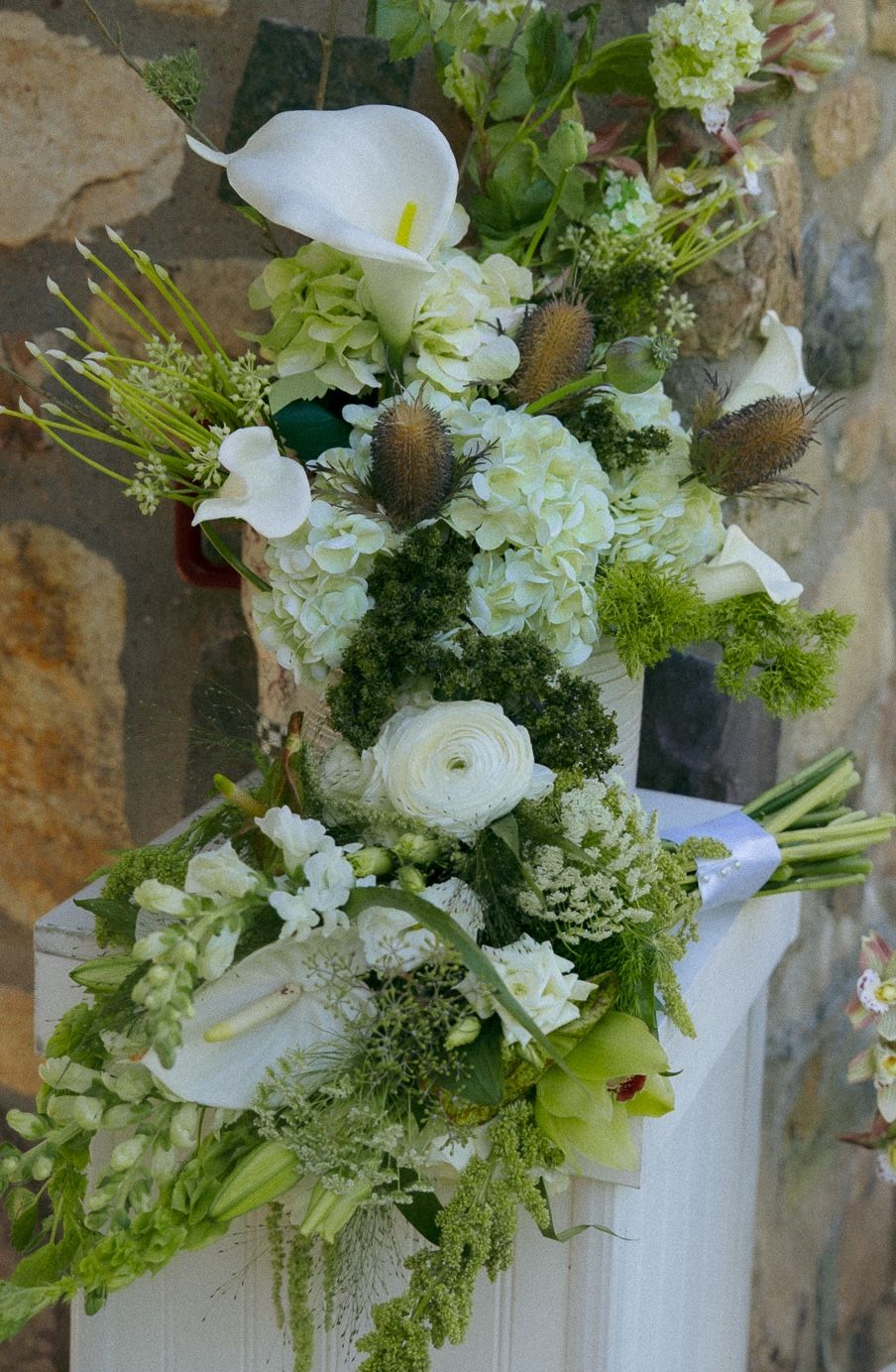 Elegant white and green floral arrangements with calla lilies and hydrangeas.