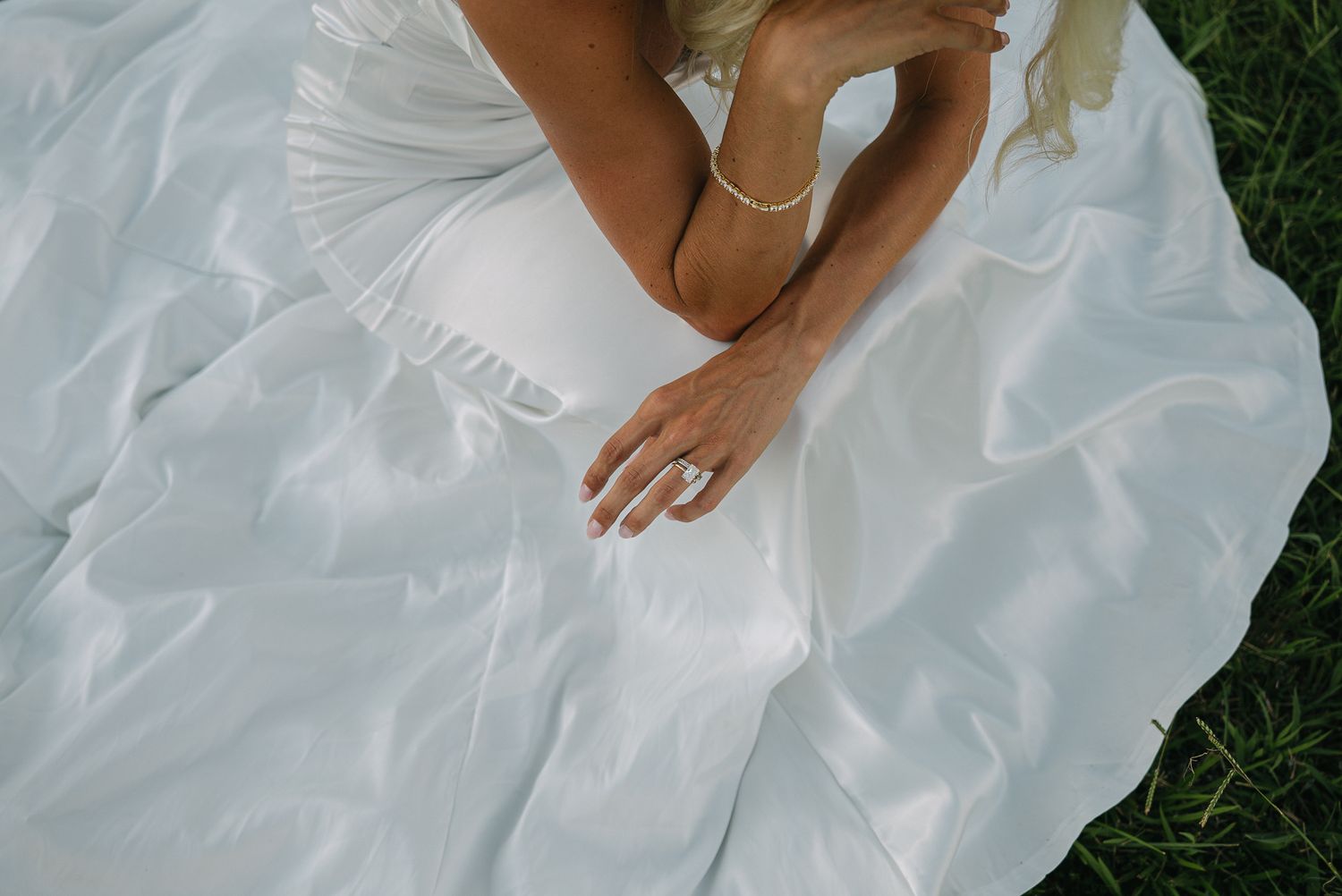 White wedding dress flowing gracefully across green grass in multiple angles.