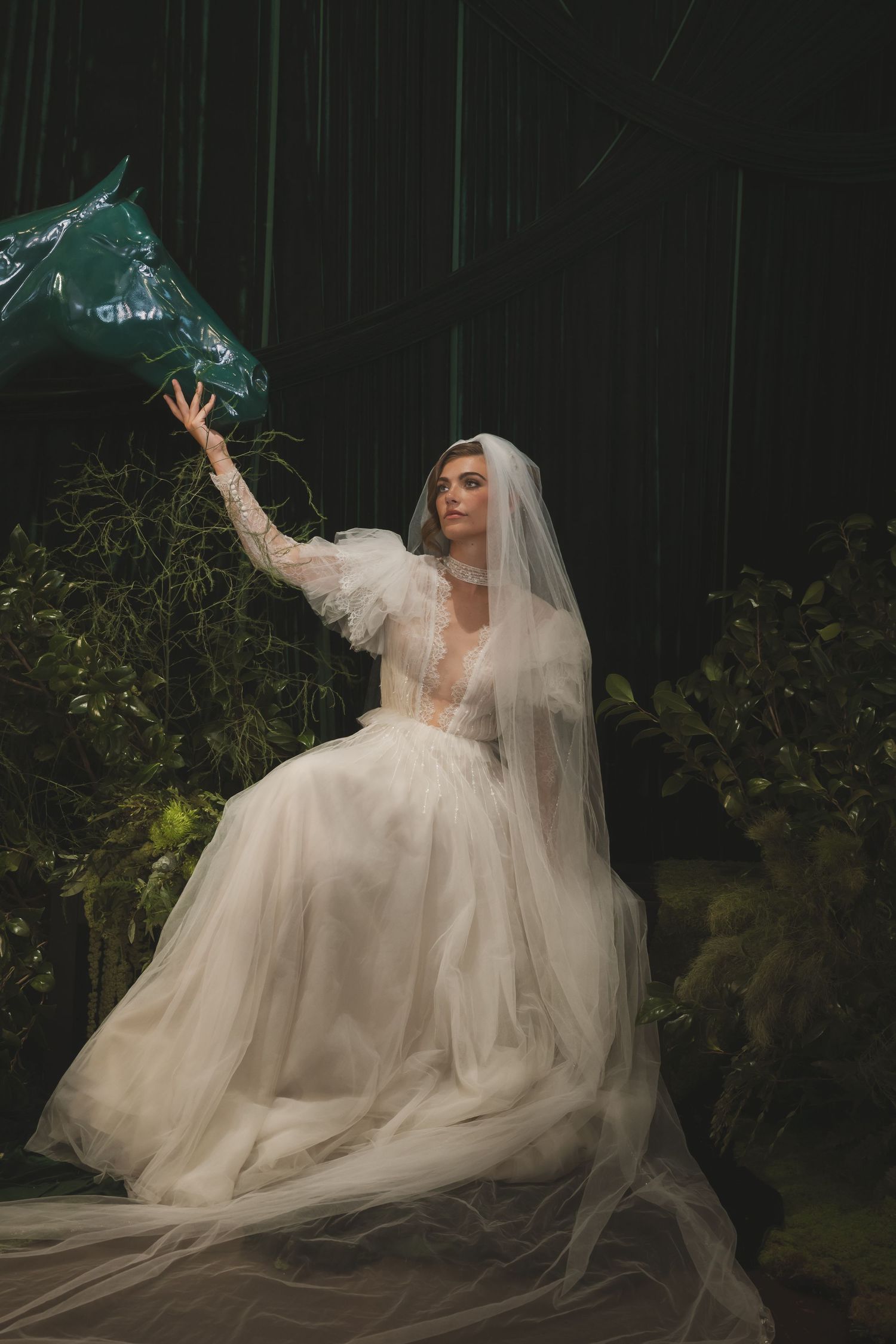 Dramatic bridal portraits in flowing white gown and veil against dark garden backdrop.