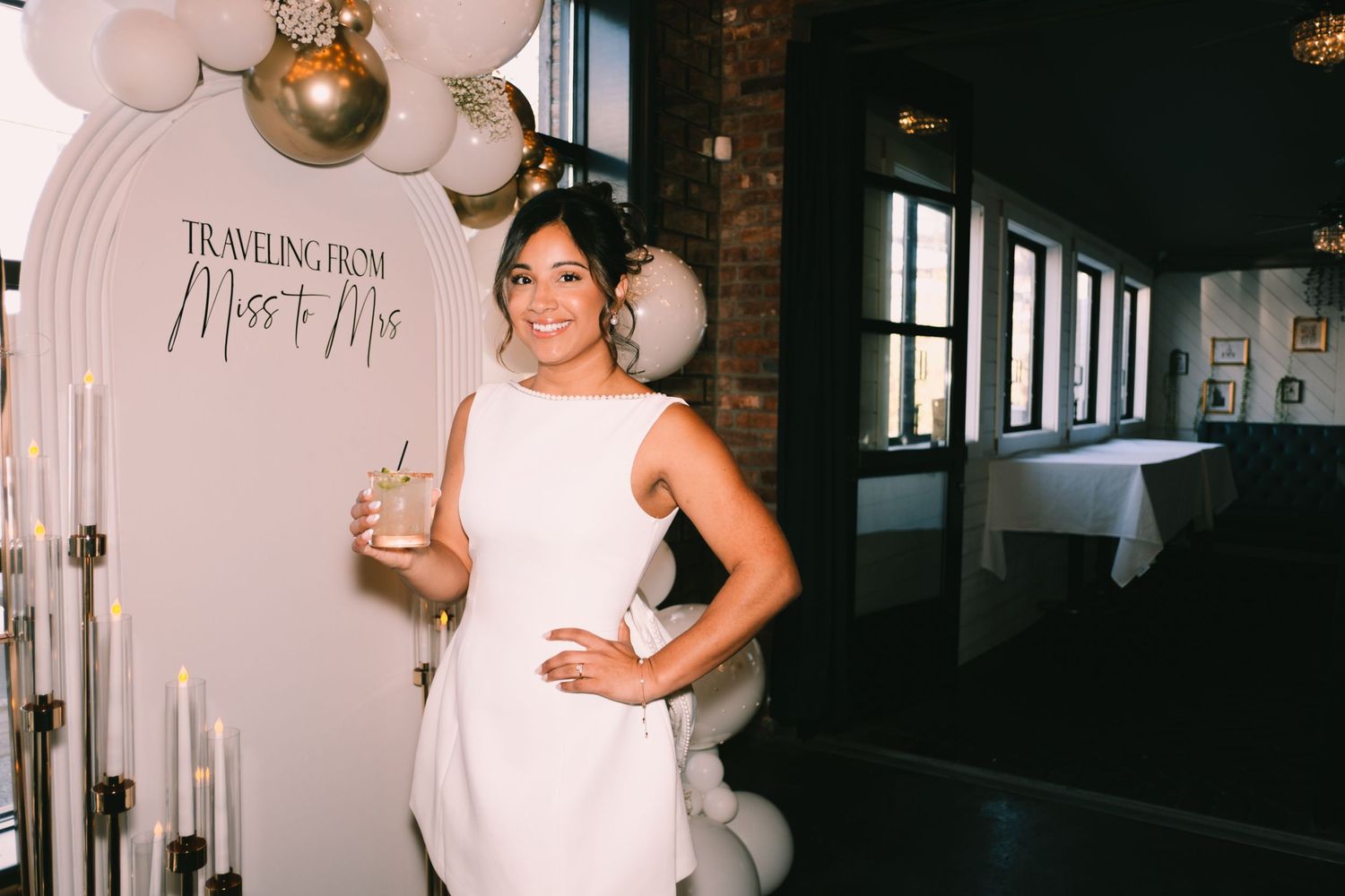 Elegant baby shower setup with balloon arch and decorative signage in pastel colors.
