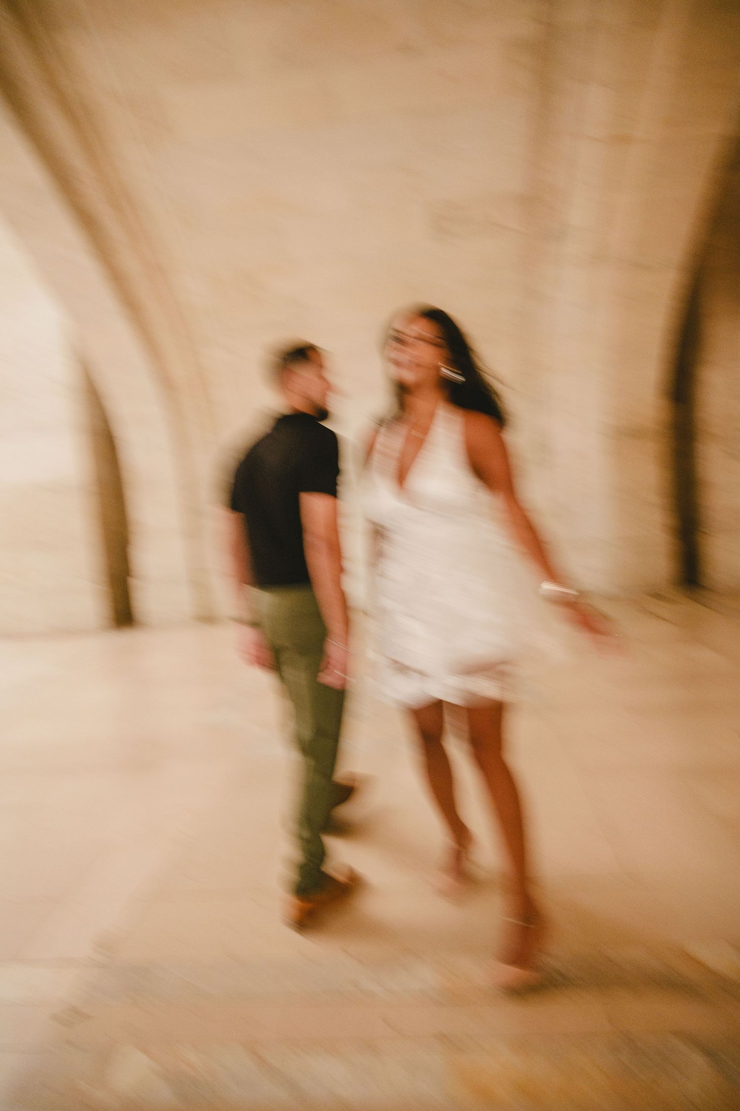 Artistic motion blur photograph of people walking in an indoor space.