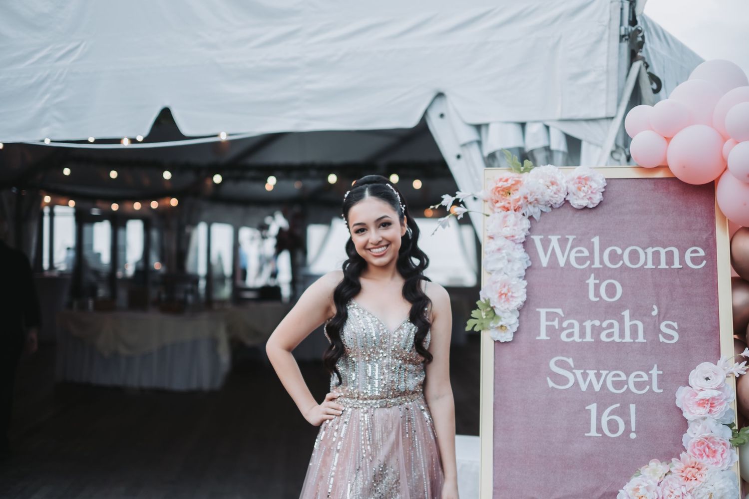 Pink and white welcome signs with floral designs at an event entrance.