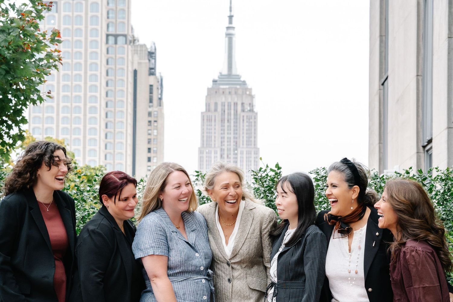 Group celebration on a rooftop with city skyline visible in background.
