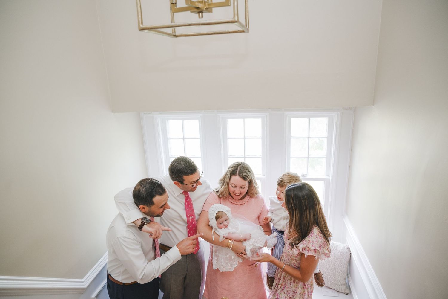 Joyful gathering in a bright white room with natural light streaming through windows.