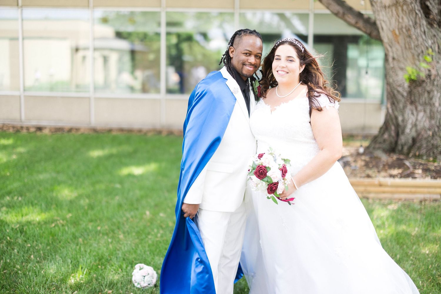 A couple takes romantic outdoor photos in formal attire with trees in the background.