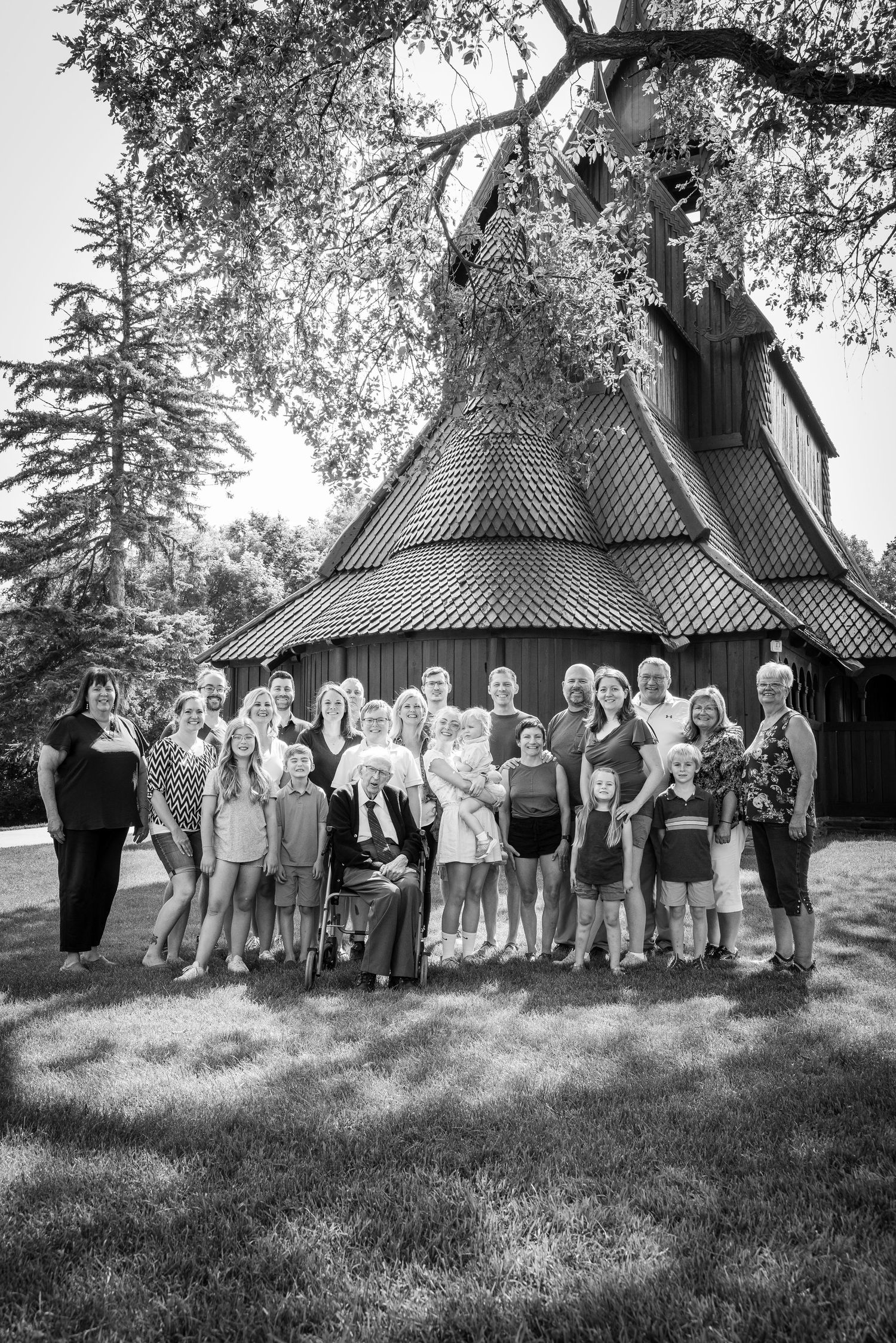 Large group photo session in black and white with a rustic building backdrop.