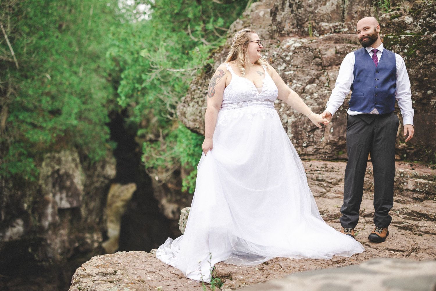 A wedding couple explores a scenic rocky outdoor location.