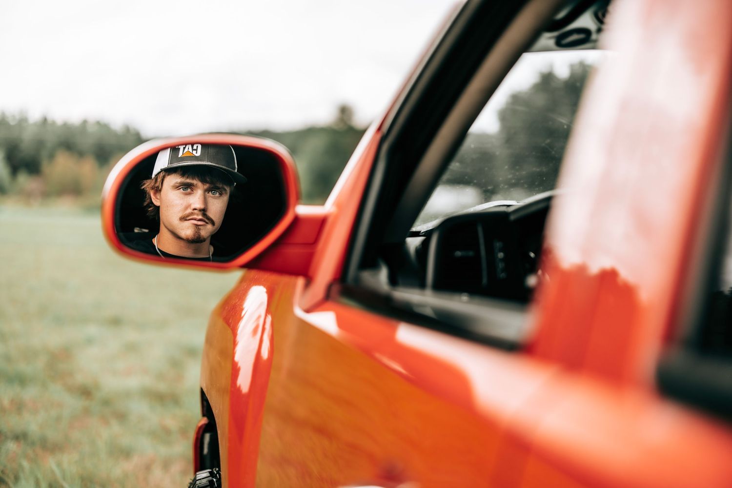 Side profile shots through red truck window during outdoor photo session.