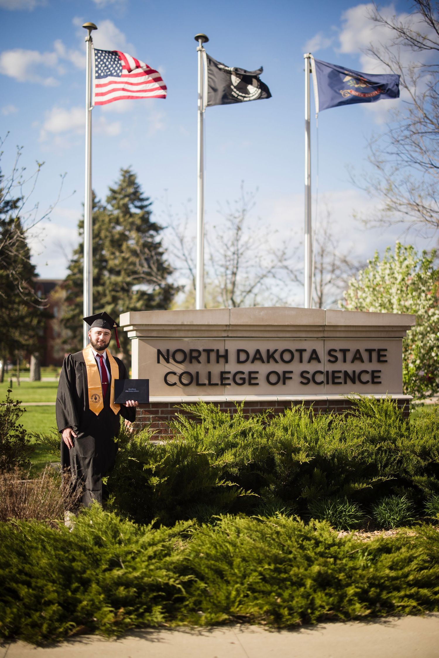 North Dakota State College of Science campus entrance sign with flags flying.