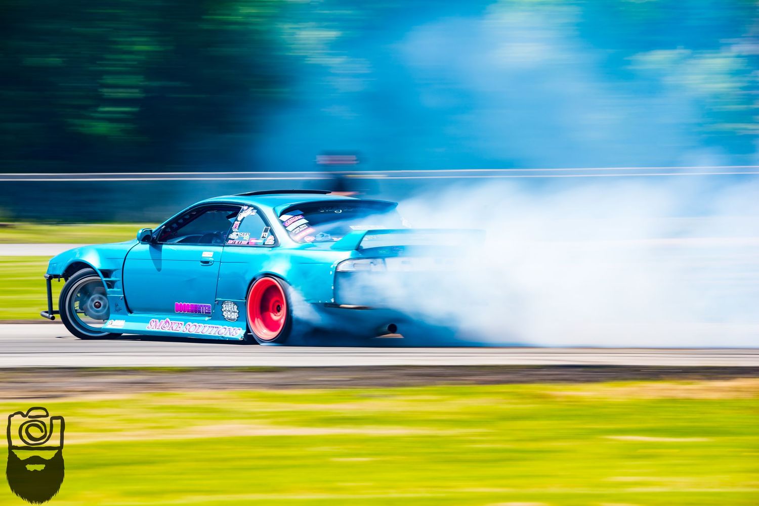 Light blue race car drifting sideways with dramatic tire smoke effects.