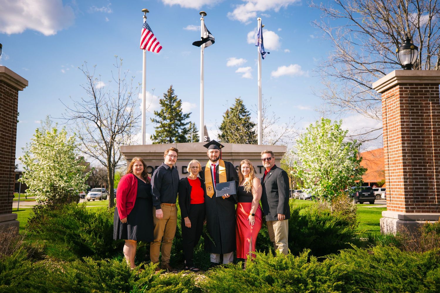 Graduation ceremony setup with American flags and outdoor seating at university.