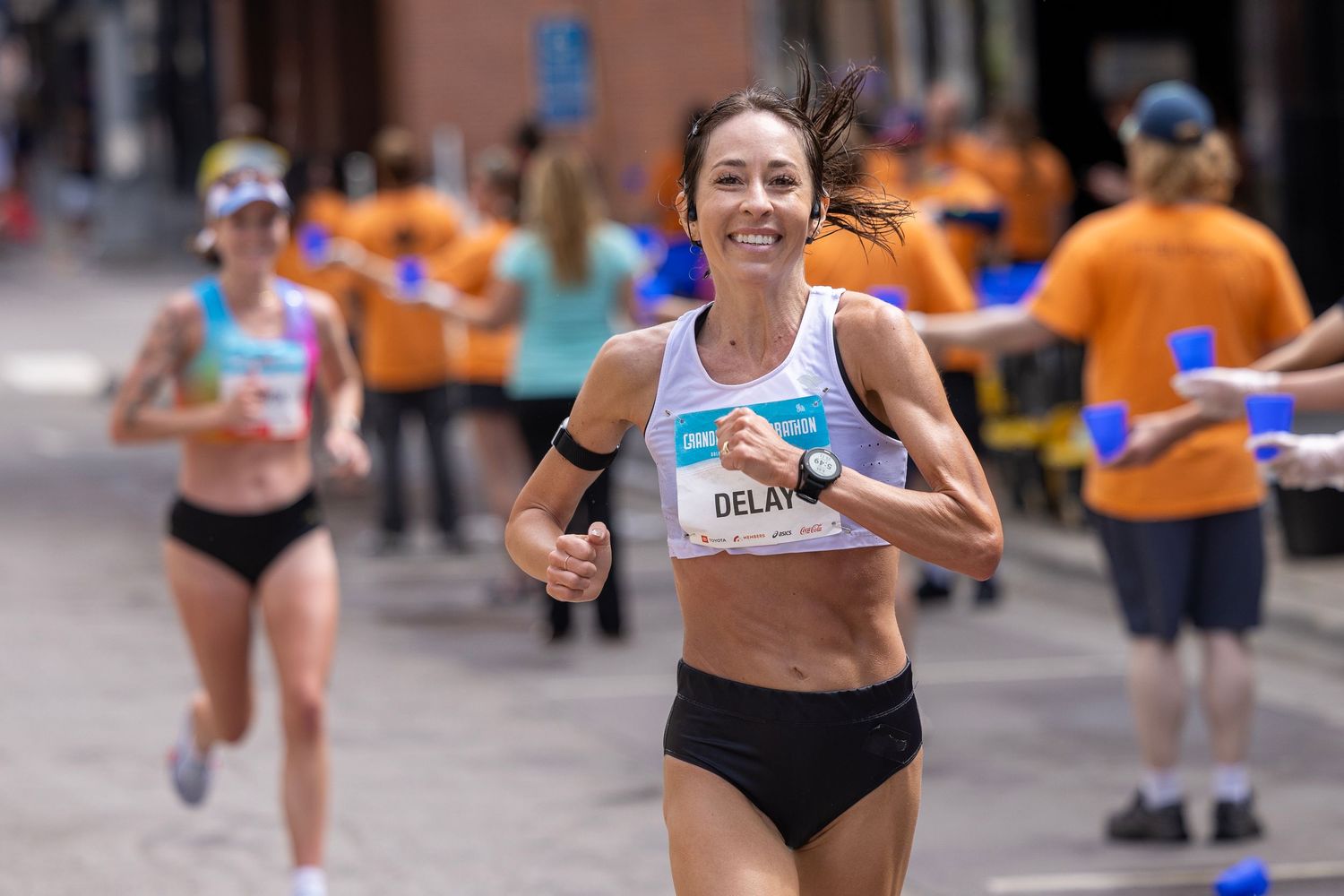 Group of runners in bright athletic wear competing in an urban marathon event.
