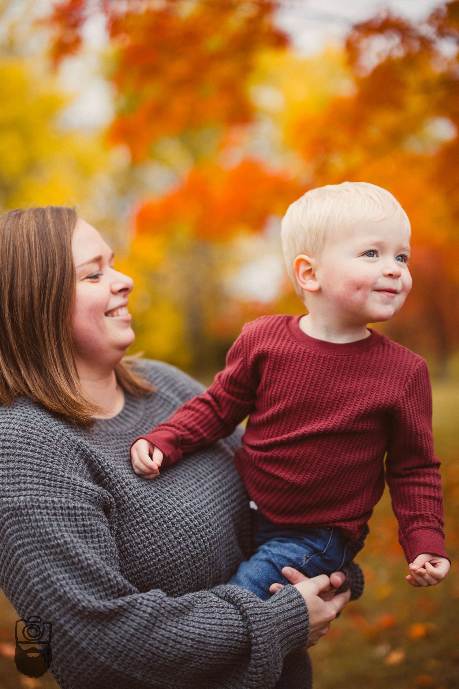 Mother and child sharing joyful moments together among colorful fall foliage.