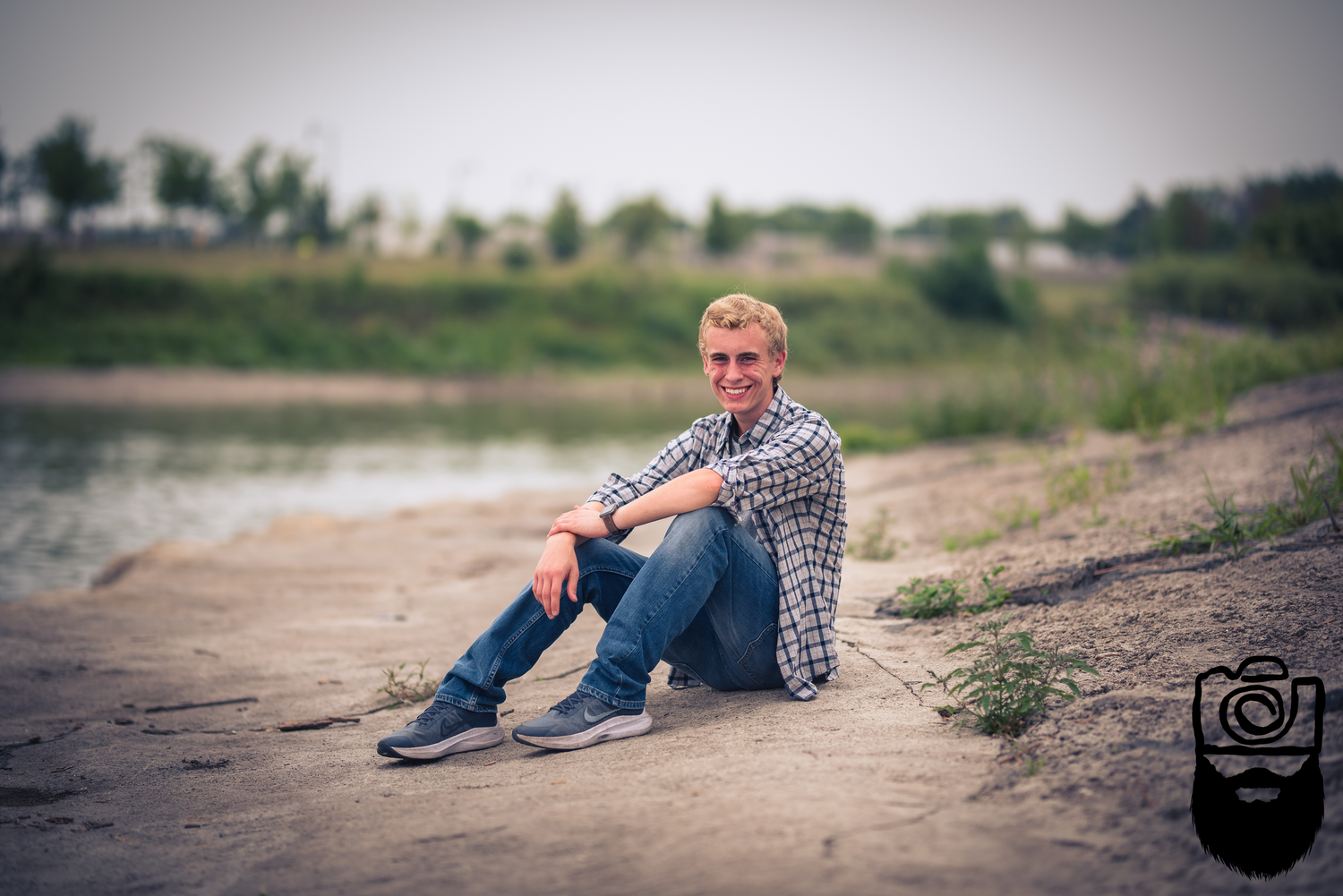 A casual outdoor portrait session on sandy terrain with natural lighting.